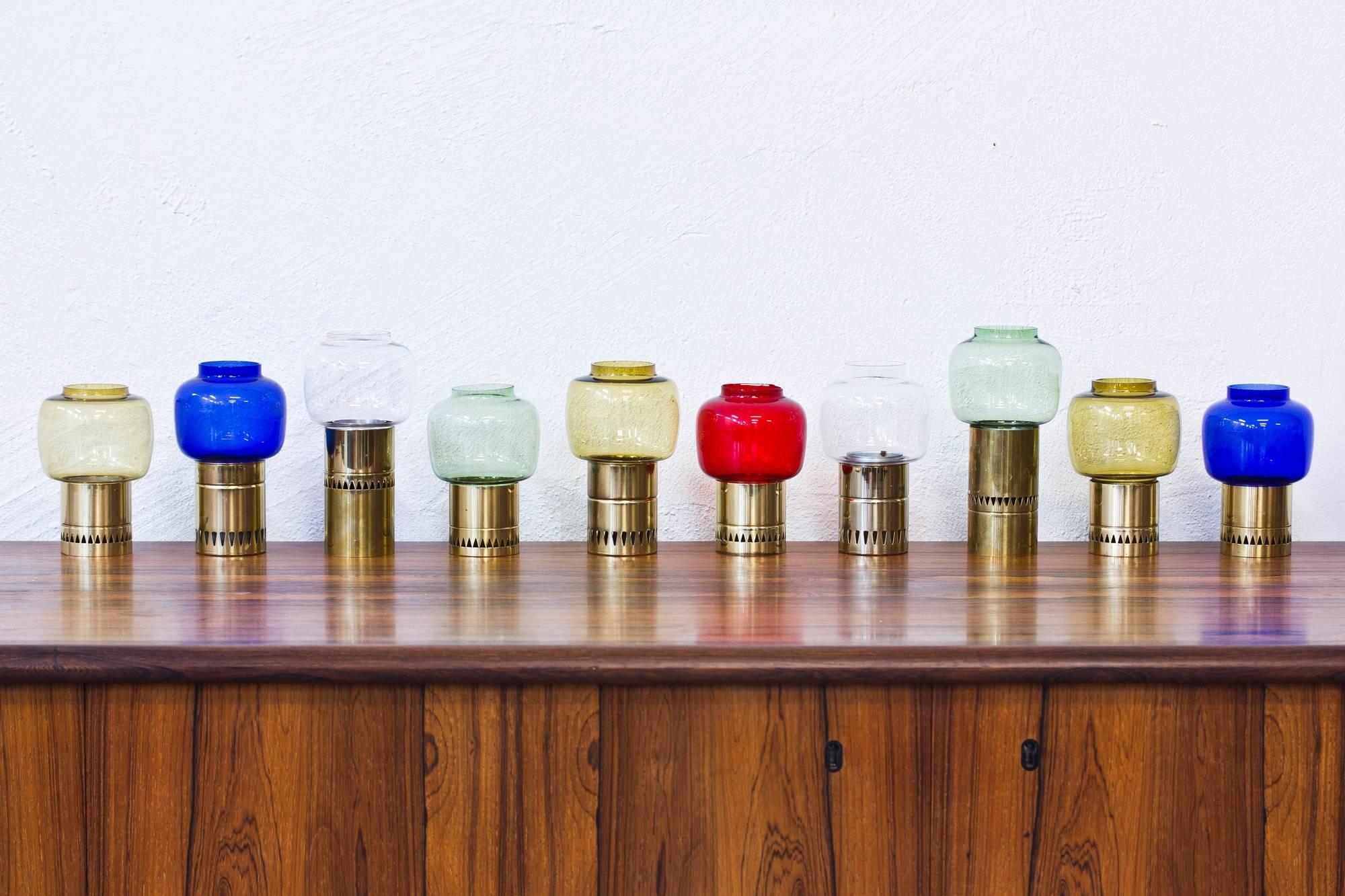Collection of ten candleholders designed by Hans-Agne Jakobsson in the 1960s. Polished brass and handblown glass shades in different colors. Produced by his own company in Markaryd, Sweden. The candleholders are individually signed with label. Very