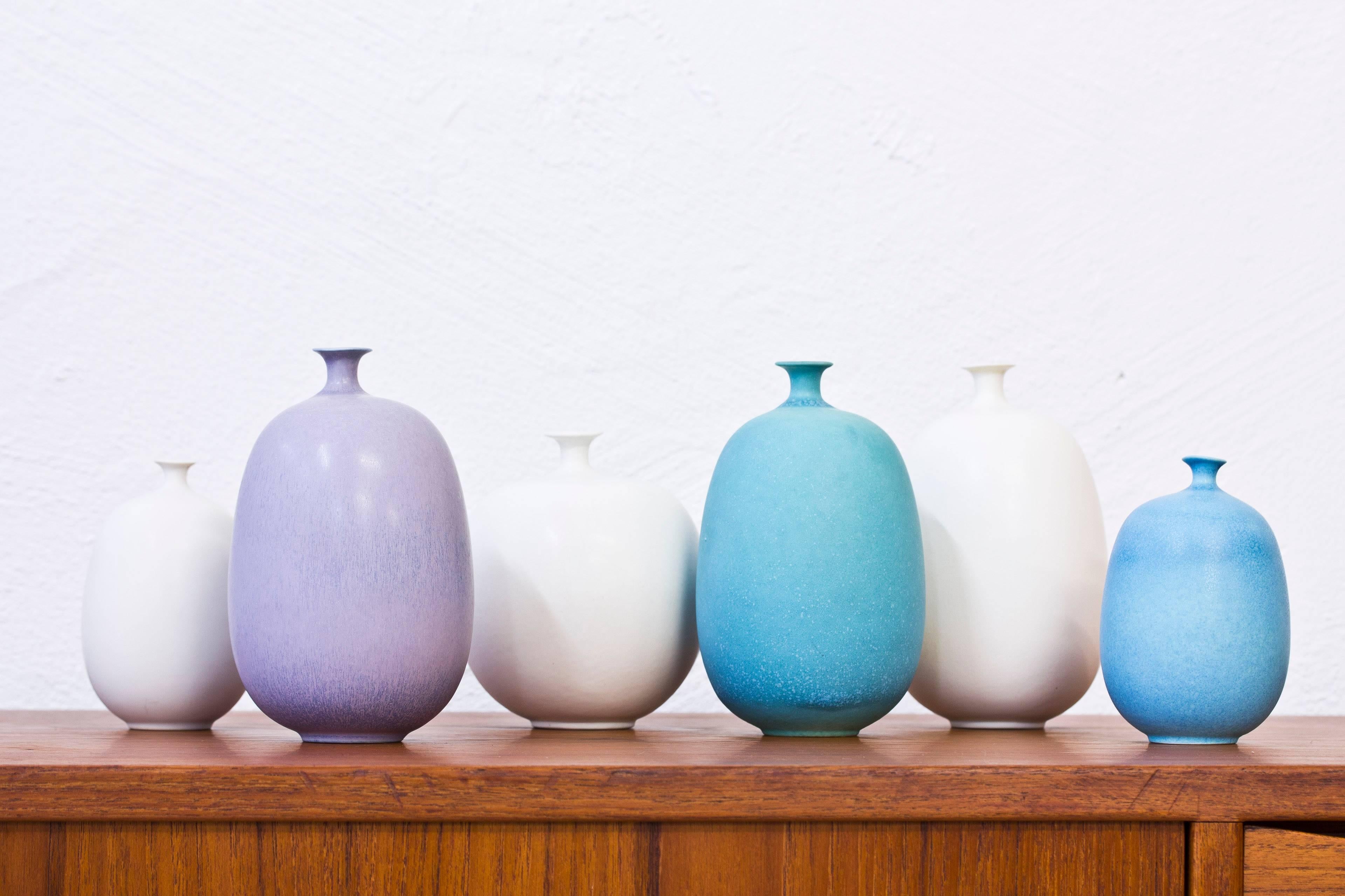Set of six stoneware vases designed by Inger Persson.  Produced by hand at Rörstrand in Sweden. Freckled glazes in blue, green, pink and white- Signed with Rörstrand hallmark, Sweden, Three crowns and Perssons signature. Height between 12-16.5 cm.