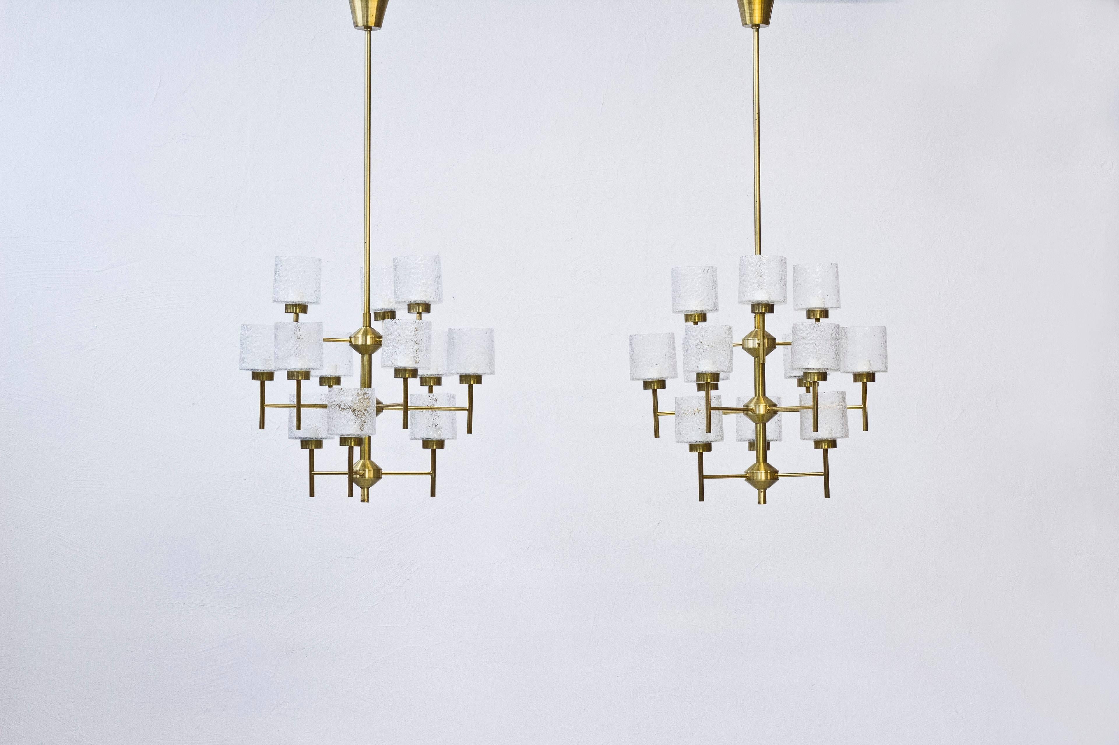 Set of four chandeliers designed by Holger Johansson. Produced in Sweden during the 1960s by Westal. Made from brass with 12 handblown clear glass shades with bubbles. Excellent vintage condition with very few signs of wear. Adjustable in height.