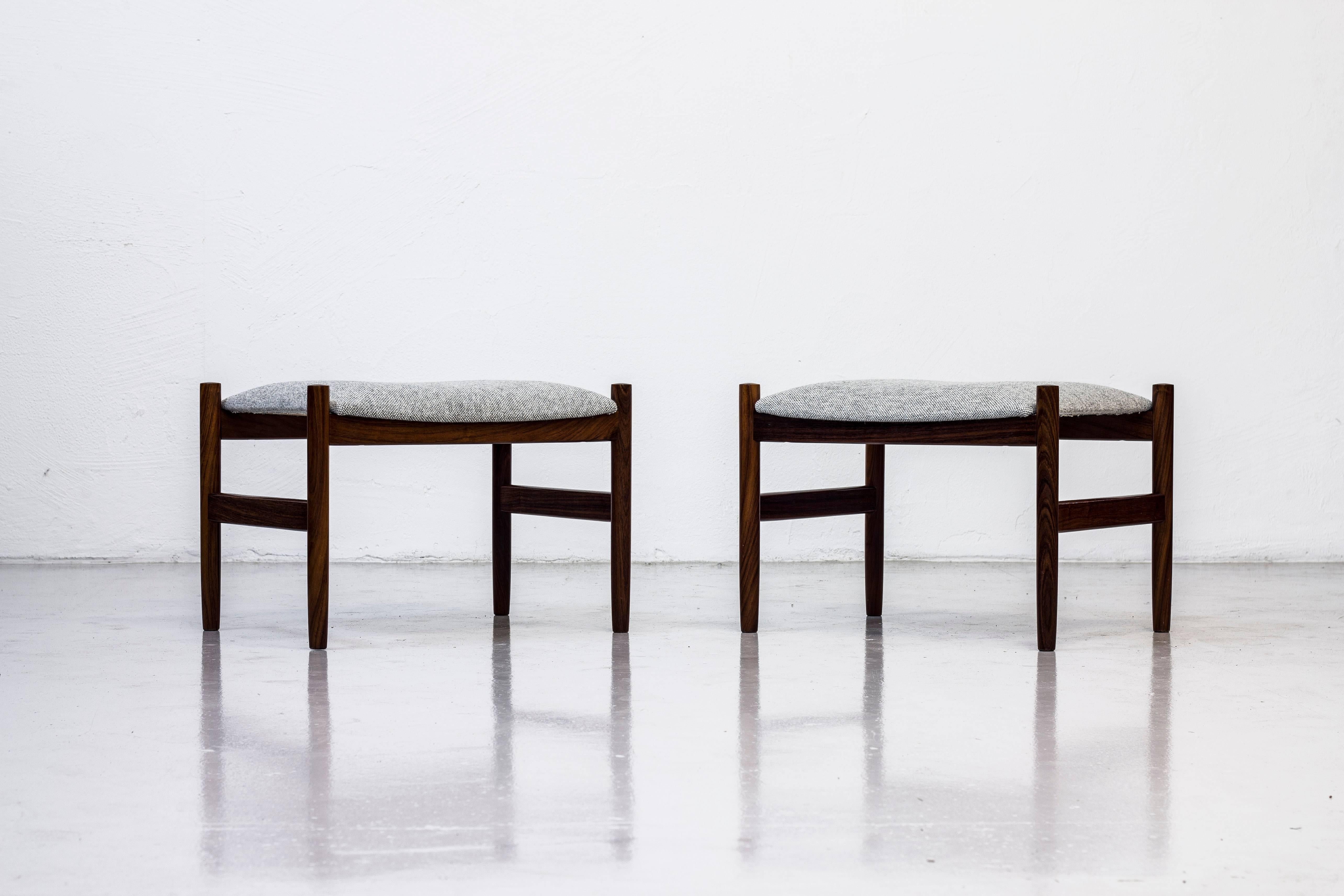 Pair of stools designed by Hugo Frandsen. Produced by his own company in Spøttrup, Denmark during the 1950s. Made from solid palisander with seats reupholstered in grey 