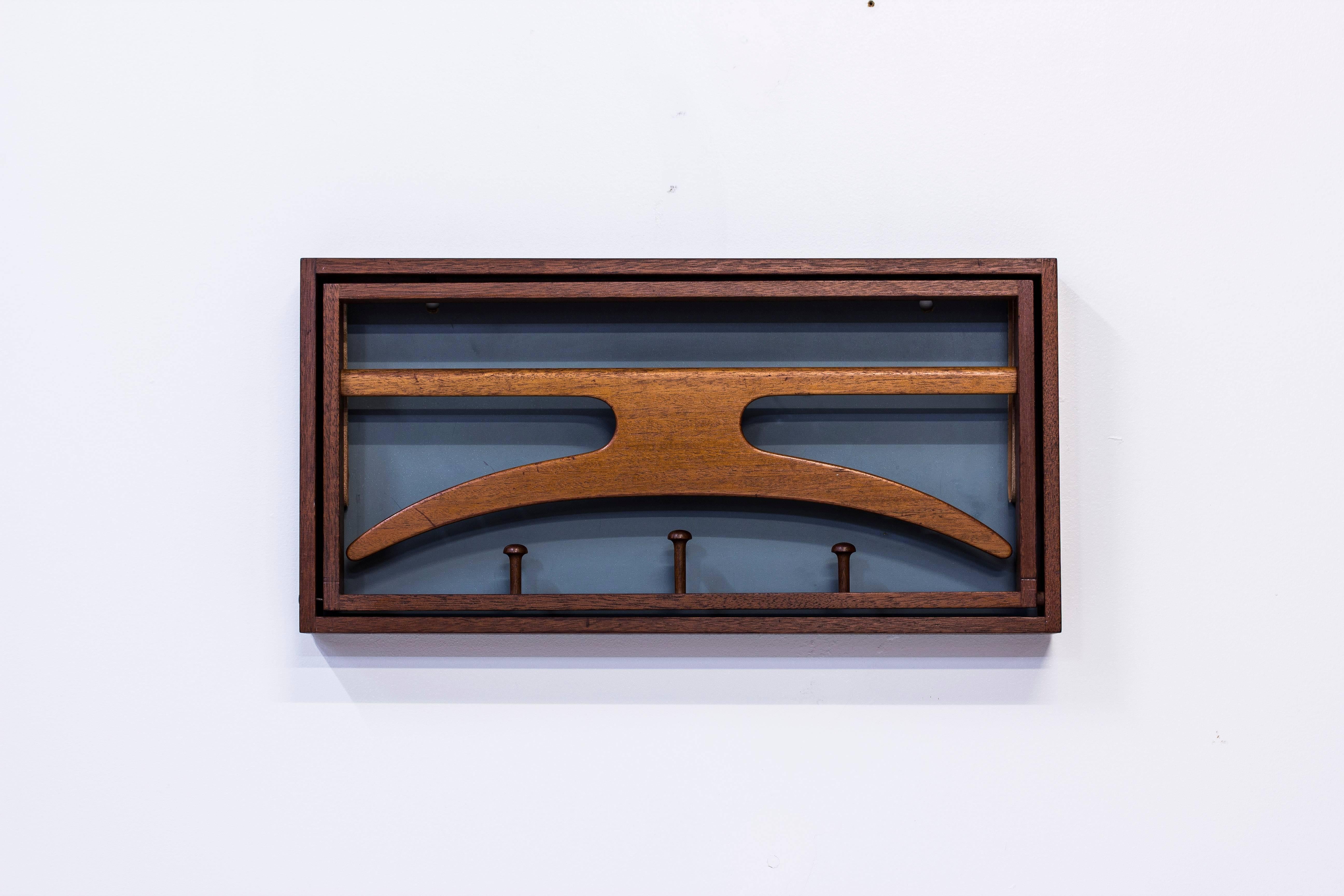 Wall-mounted valet designed by Adam Hoff & Poul Østergaard. produced in Denmark during the late 1950s by Virum Møbelsnedkeri. Solid teak frame with visible joinery, original leather straps and lacquered back part. Very good condition with light wear