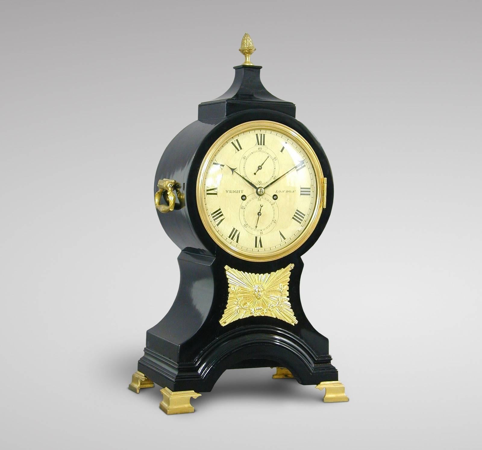 George III ebonized striking balloon bracket clock signed Wright, London, circa 1780. The case of waisted form with brass handles to the sides and concave moulding to the top surmounted by a pineapple finial, the front applied with a brass sunburst