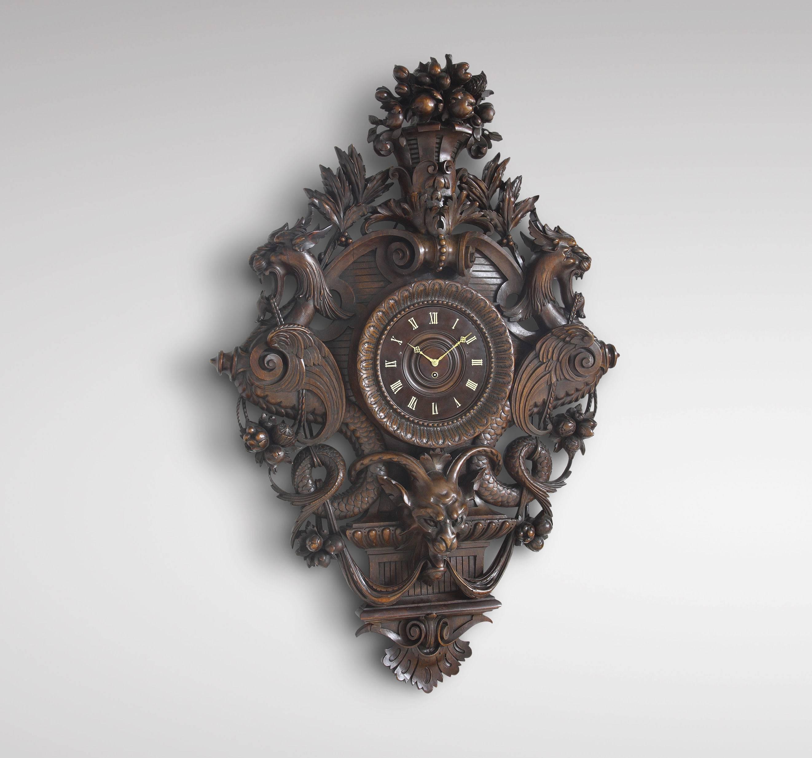 Exceptional carved walnut wall clock by Charles-François Rossigneux, Paris, circa 1870. The clock dial in waxed and polished walnut, with Gothic-style Roman hour chapters painted in white, chased gilt-brass hands; the case, in the form of a