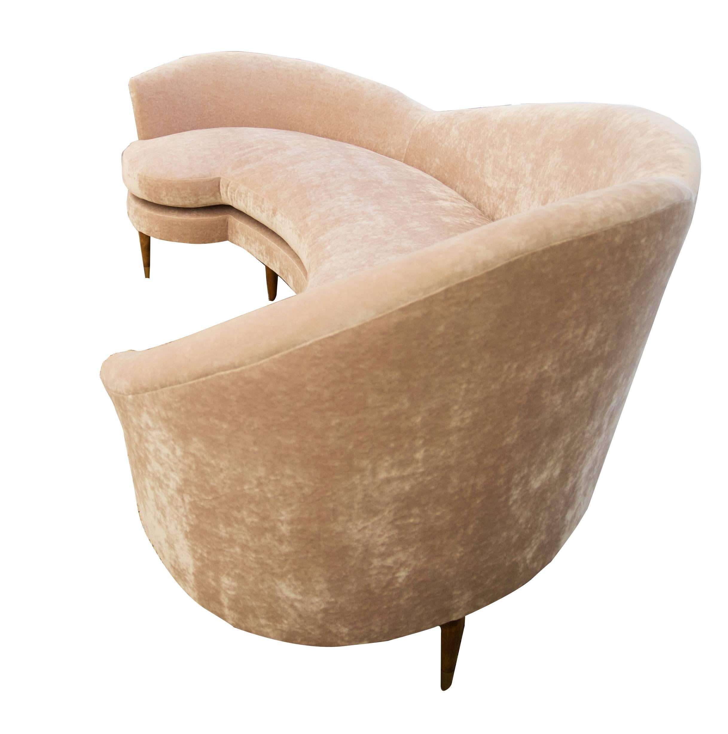 Large curved sofa inspired by Italian mid-century design. Upholstered in blush pink crushed velvet. Velvet is napless. Single cushion with foam, dacron, and down. Tight back that is also soft and accommodating for lounging. Art Deco peg legs with