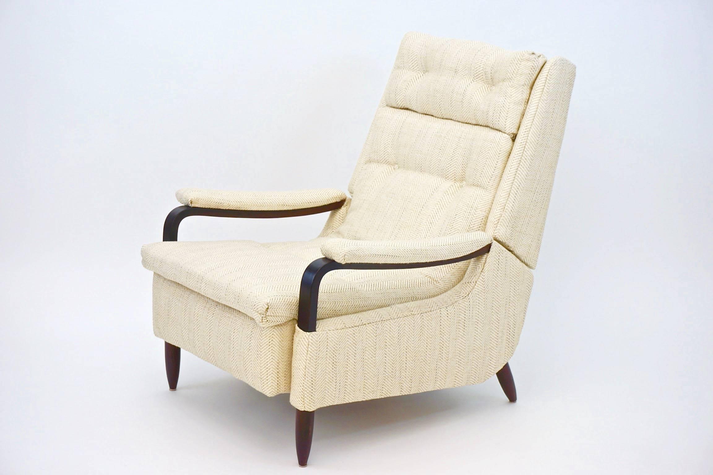 Vintage 1960s Recliner newly upholstered in creme herringbone tweed.  Completely Restored.  Wooden arms and legs.  The chair features a fold out leg rest that comes out when the chair is reclined.

