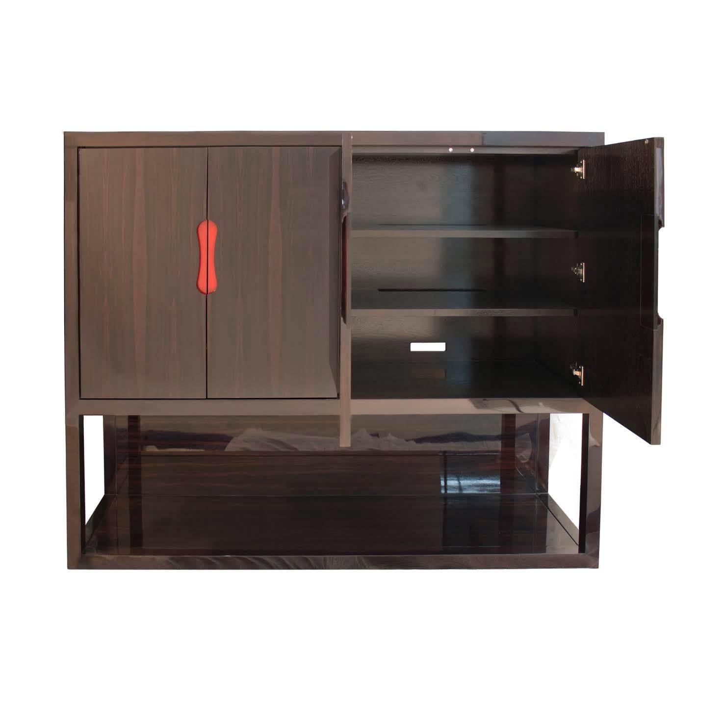 Cabinet with four doors and side panels in Macassar ebony, high gloss full fill. Frame in walnut stained to match. Recessed handles in red polished lacquer. Shelves are adjustable.