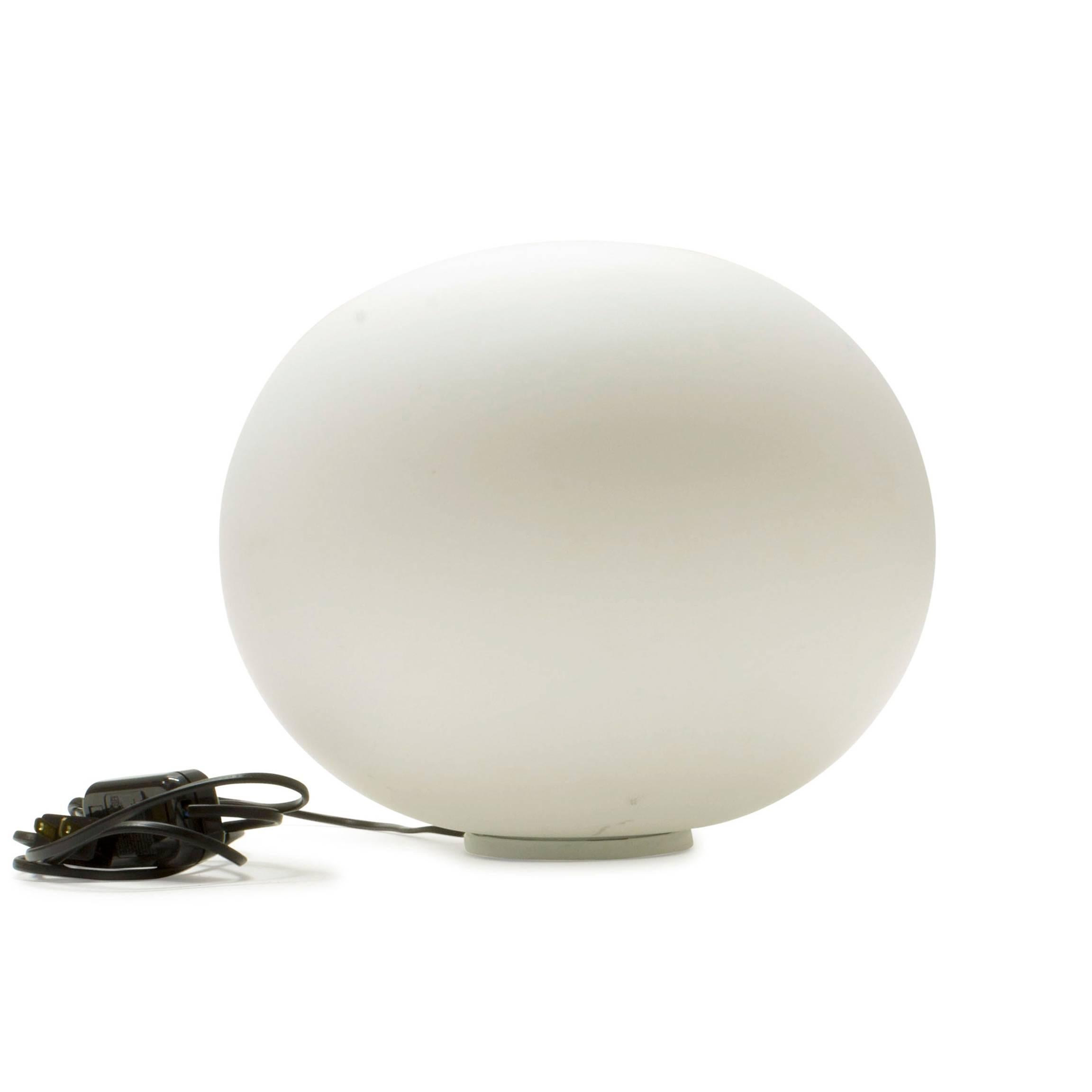 Part of the popular Glo ball series, the Glo ball basic was created in 1998 by artist Jasper Morrison to invoke the radiant calm of a full moon. This unique table lamp has a white acid-etched blown glass diffuser, and the glass body is 30%
