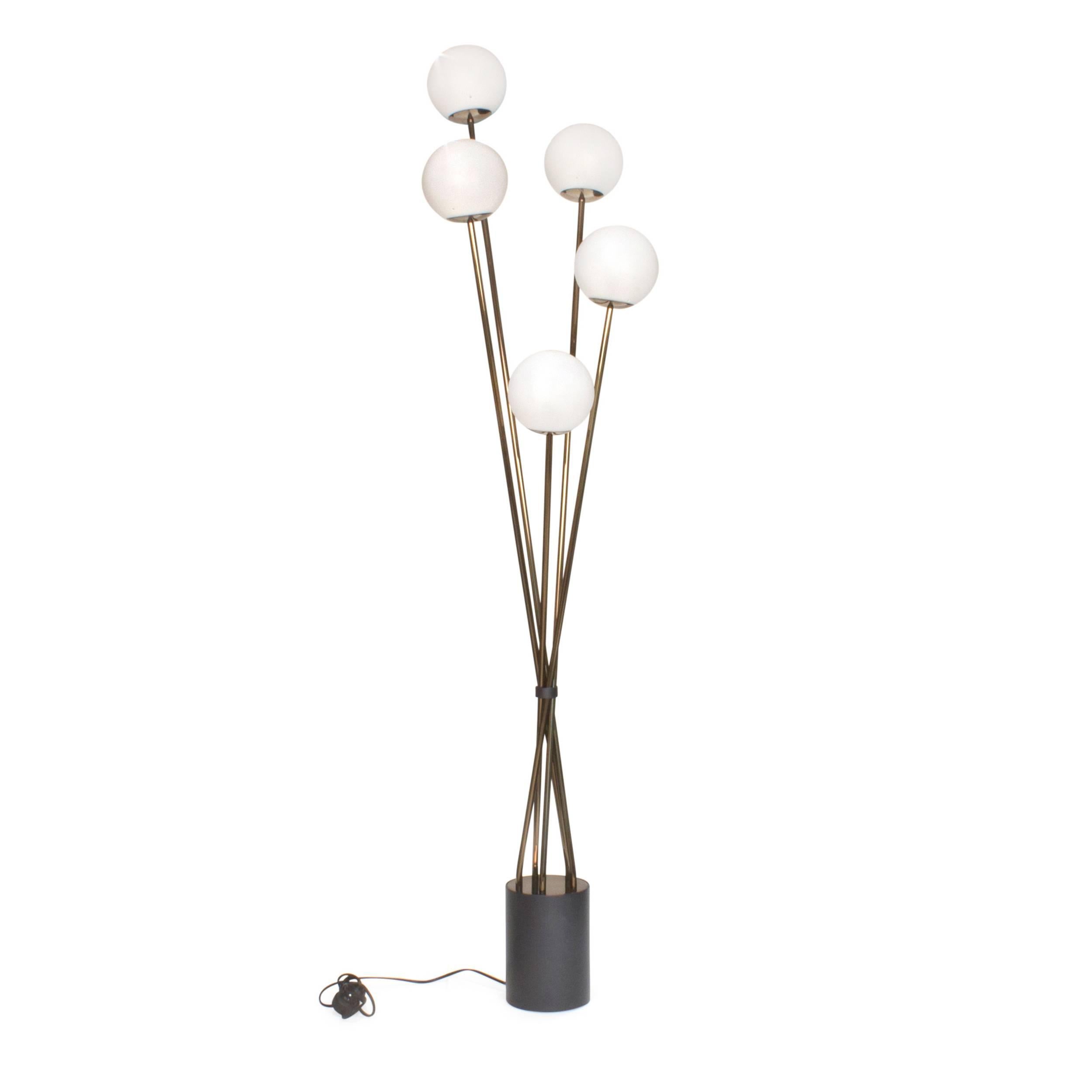 Floor lamp composed of a cylindrical metal base with black Tin finish on which lay thin stems with five gold nickel and frosted glass diffusers.