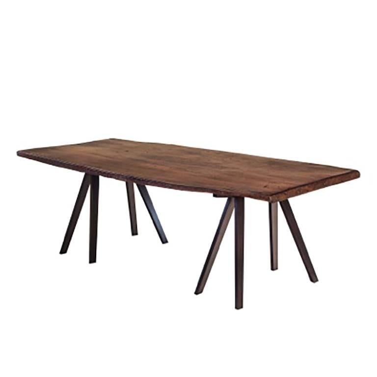 Antique teak plank with a metal base and contemporary sawhorse legs.