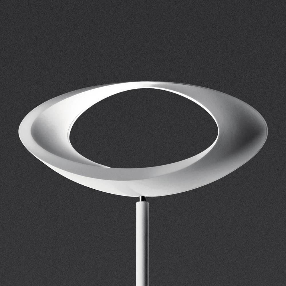 Steel base and stem; body lamp in painted die-cast aluminium. The indirect light shapes the body lamp, bringing out its winding form and giving it the astonishing appearance of a ring of light.

White. Dimmable Halogen.