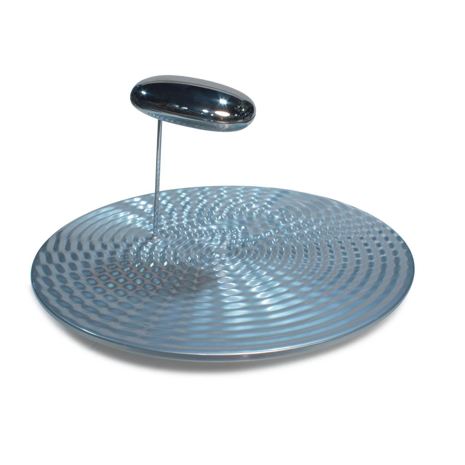 A ceiling fixture that places a floating assembly of large pebbles below a simple modern disc. These in turn reflect each other bouncing light between their taught bio - morphic surfaces and reflecting the environment around them. During the day the