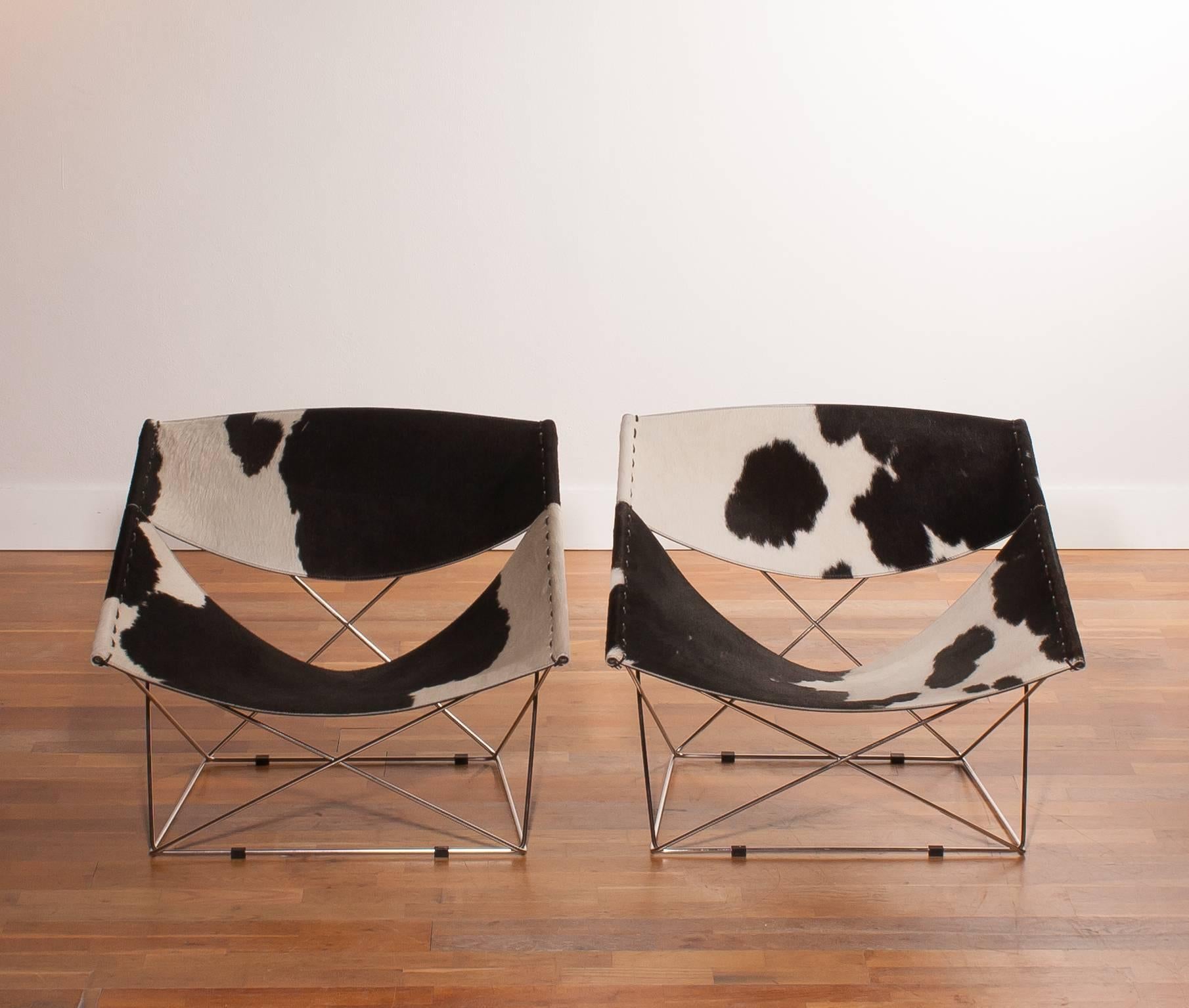 Beautiful ornate ' Butterfly ' lounge chairs designed by Pierre Paulin for Artifort.
At this particular chairs are the cross-mounted steel rods welded together.
Very nice combination with the robust cow fur leather.
The chairs are in excellent