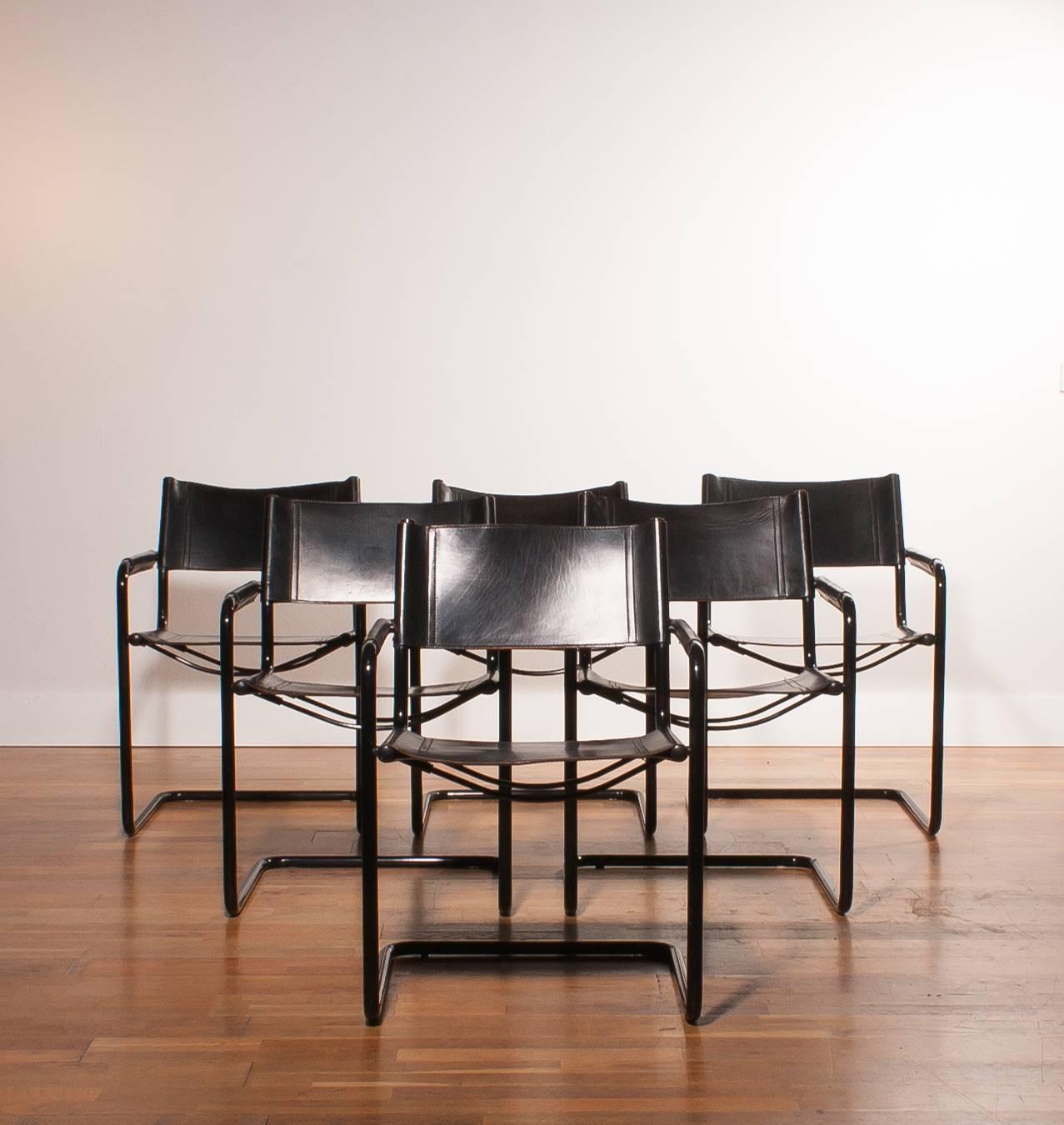 This set of dining chairs was produced in Italy.
The chairs feature tubular black metal frames and the seats, backrest and armrests are made from sturdy black leather.
The leather has a nice patina.
Period 1970s.
        