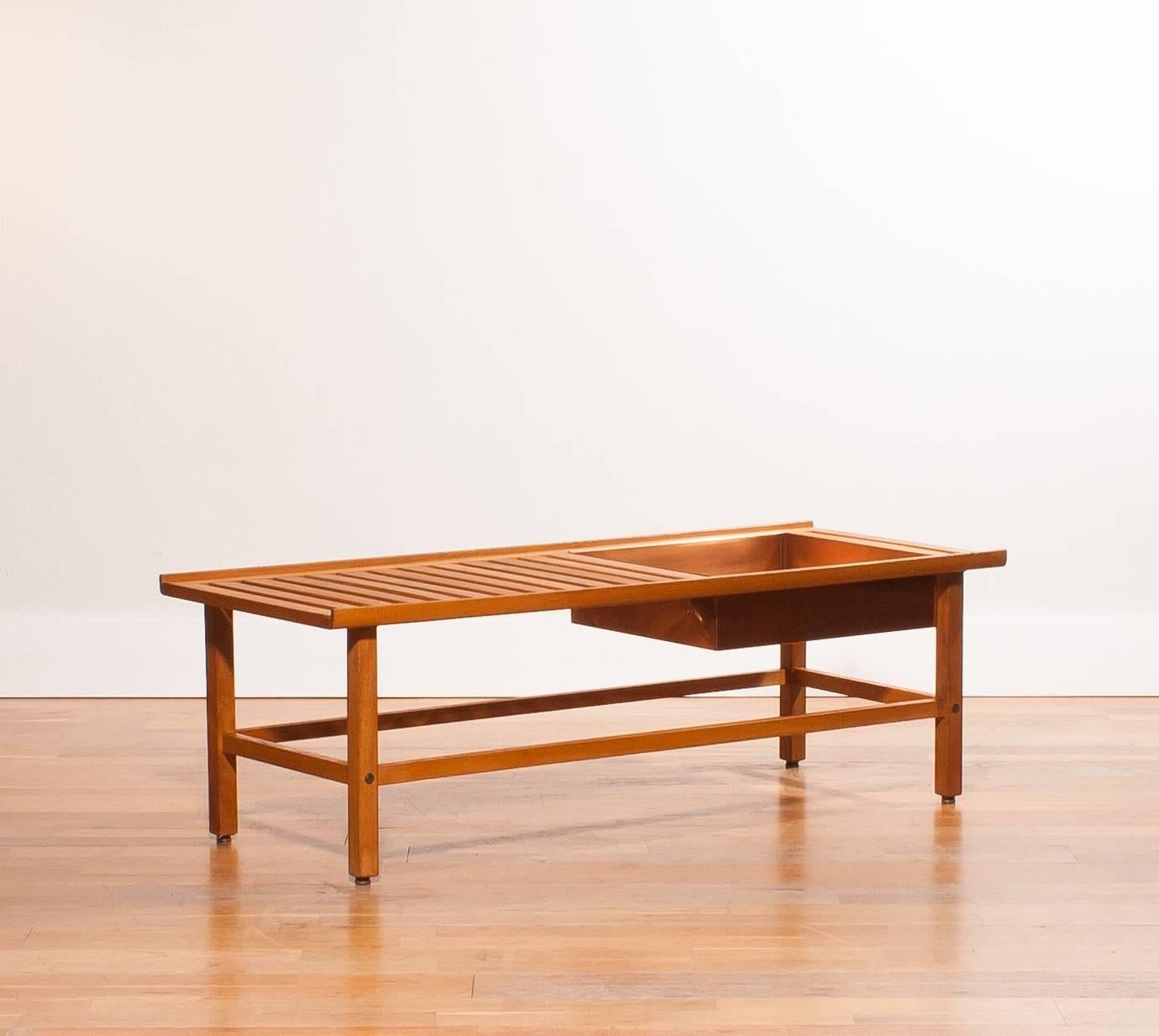 A beautiful plant bench designed by Yngve Ekström.
The bench is made of teak.
There is room for plants of flowers in the copper compartment.
It is in an excellent condition.
Period 1950s
Dimensions: H 39 cm , D 48 cm , W 120 cm.