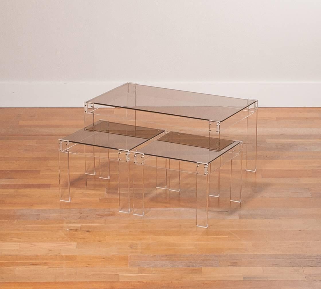 A beautiful set of Italian nesting tables.
The set consist of three tables who are made of plexiglass with smoked glass table tops.
There is one large and the other two have the same dimensions.
They are in a good condition with some wear