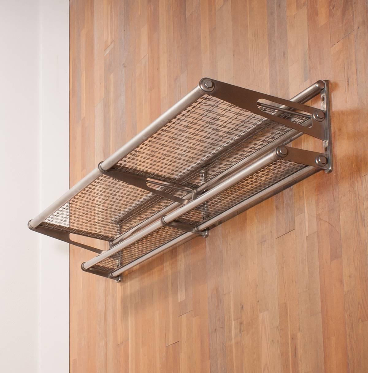 Beautiful wall-mounted luggage rack.
This rack is made of stainless steel.
It is coming out of a train compartment.
You can use the rack as a coatrack or as a bookshelf, but it looks also great in your kitchen for your pots and pans and even in