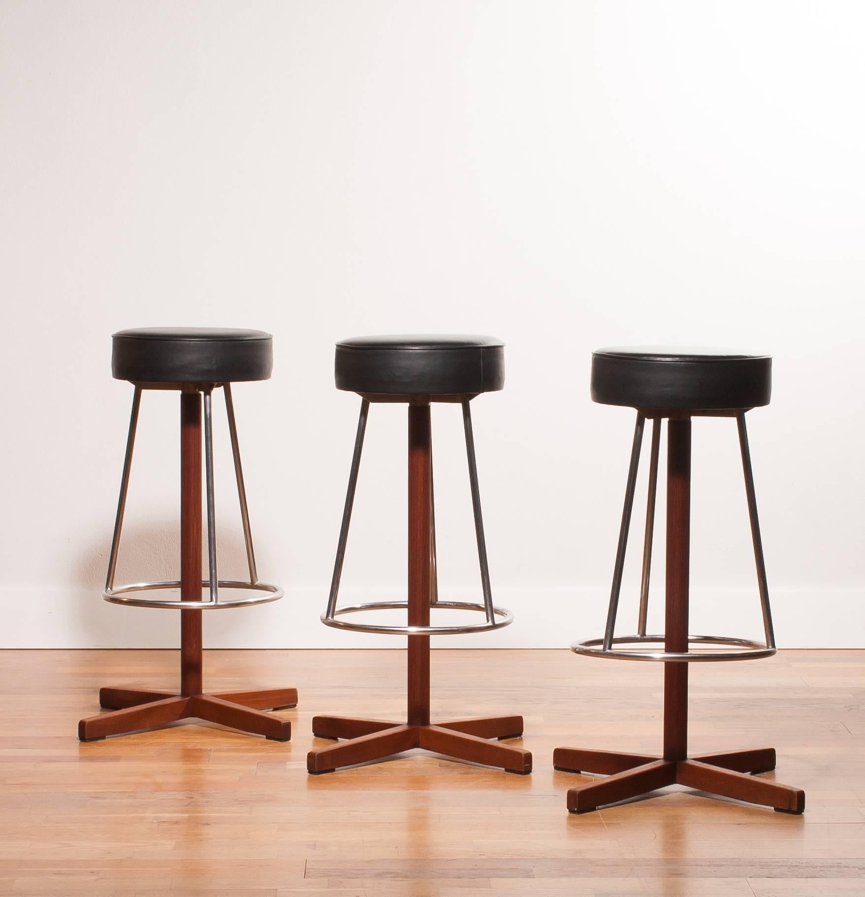 Very beautiful set of three bar stools.
The stools are made of a black leathered seating on a swivel steel frame and a teak leg.
They are in a very nice condition.
Period 1960s
Dimensions: H. 80 cm, W. 41 cm, D. 41 cm.
                