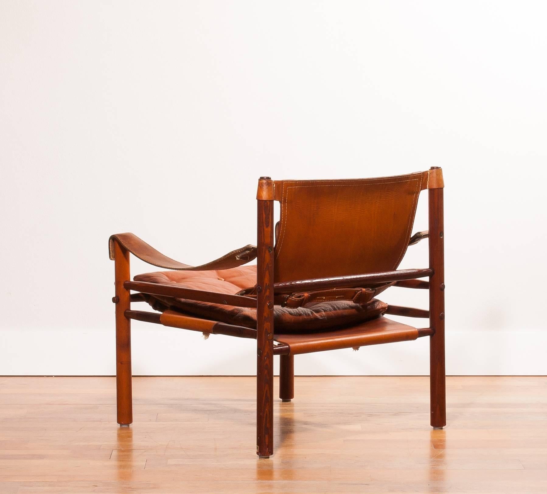A beautiful 'Sirocco' safari chair designed by Arne Norell and produced by Arne Norell AB in Aneby Sweden.
The frame is made of oak and the seating , rug and armrest are made of very sturdy saddle leather.
There is an extra leather cushion for the