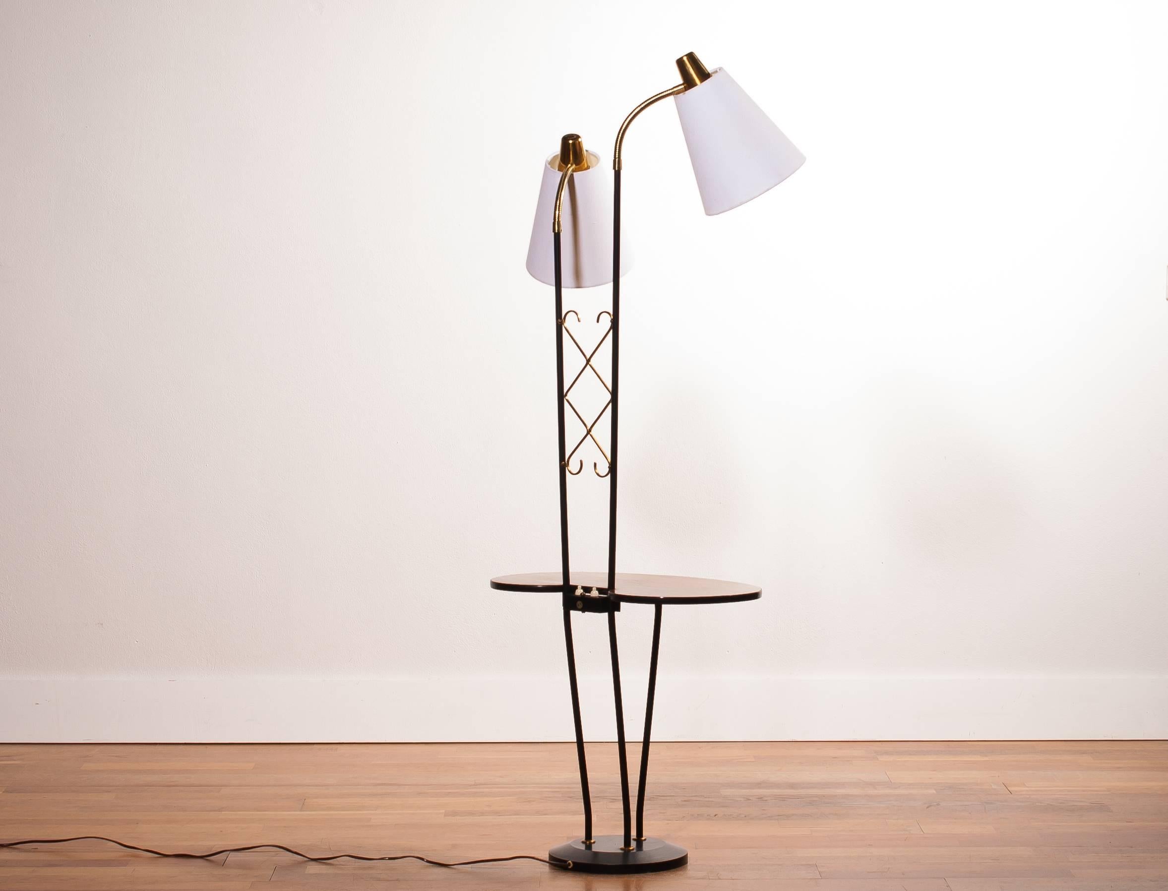 Beautiful floor lamp consistent two lamps and a table made in Sweden.
It features a metal black with brass frame, a teak table and two lamps with new white shades.
It is in a wonderful condition.
Period 1950s
Dimensions: H 150 cm, W 54 cm , D 33