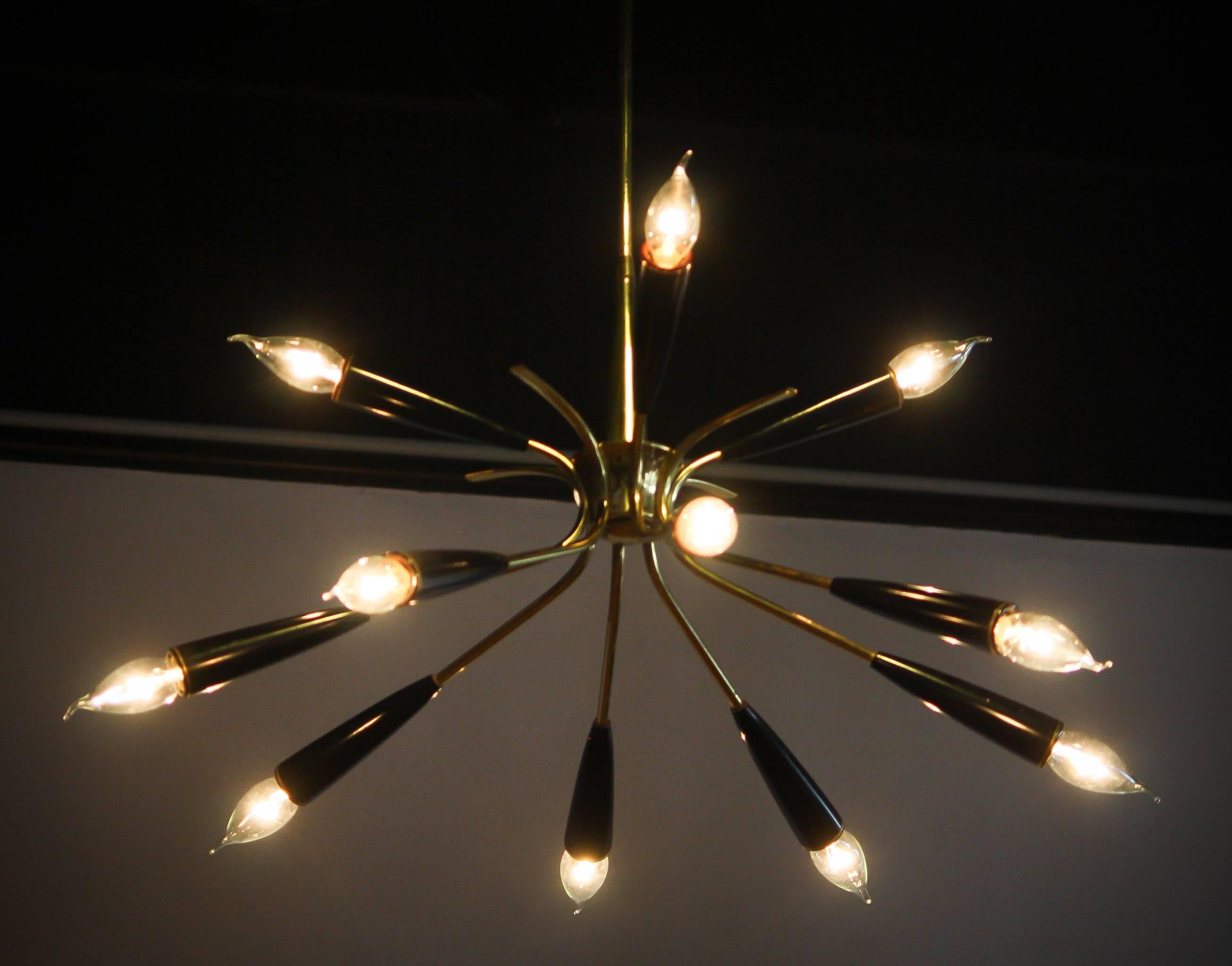 Beautiful Italian Sputnik chandelier.
The chandelier has eight brass arms with twelve black metal fixtures.
 It is in a nice and working condition.
Period 1950s
Dimensions : H.70 cm , ø 60 cm.
  