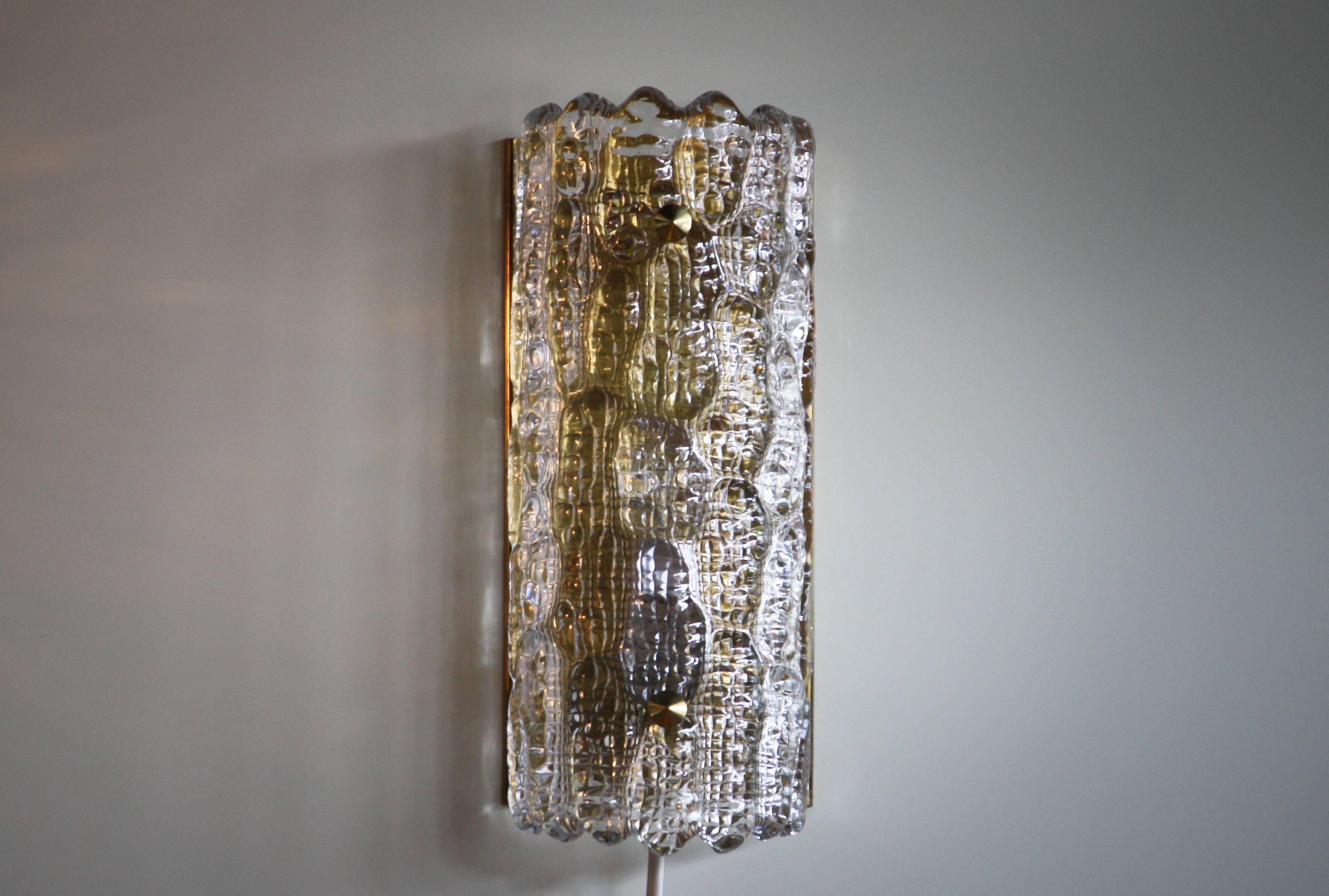 Beautiful wall light designed by Carl Fagerlund for Orrefors, Sweden.
This lamp is made of brass and crystal textured glass shade what reflect a wonderful light.
Period 1960s
Dimensions: H 28 cm, W.12 cm, D.8 cm.