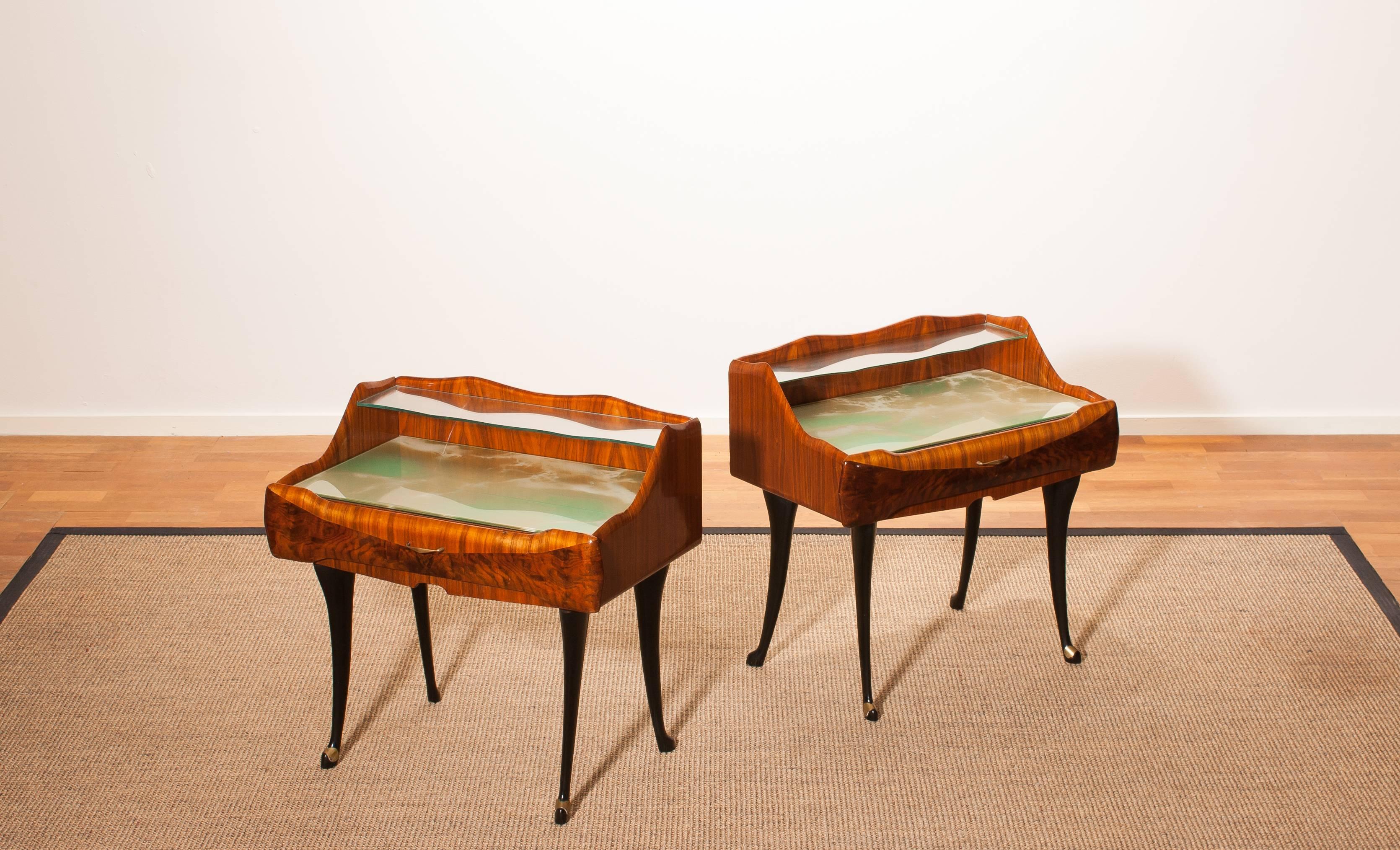 This stylish pair of 1950s nightstands by Paolo Buffa are in excellent condition
Stylish glass shelf, sculpted two-tone frame and black slim legs with brass shoes add.
The top of the nightstands is covered with a marbled glass top and a