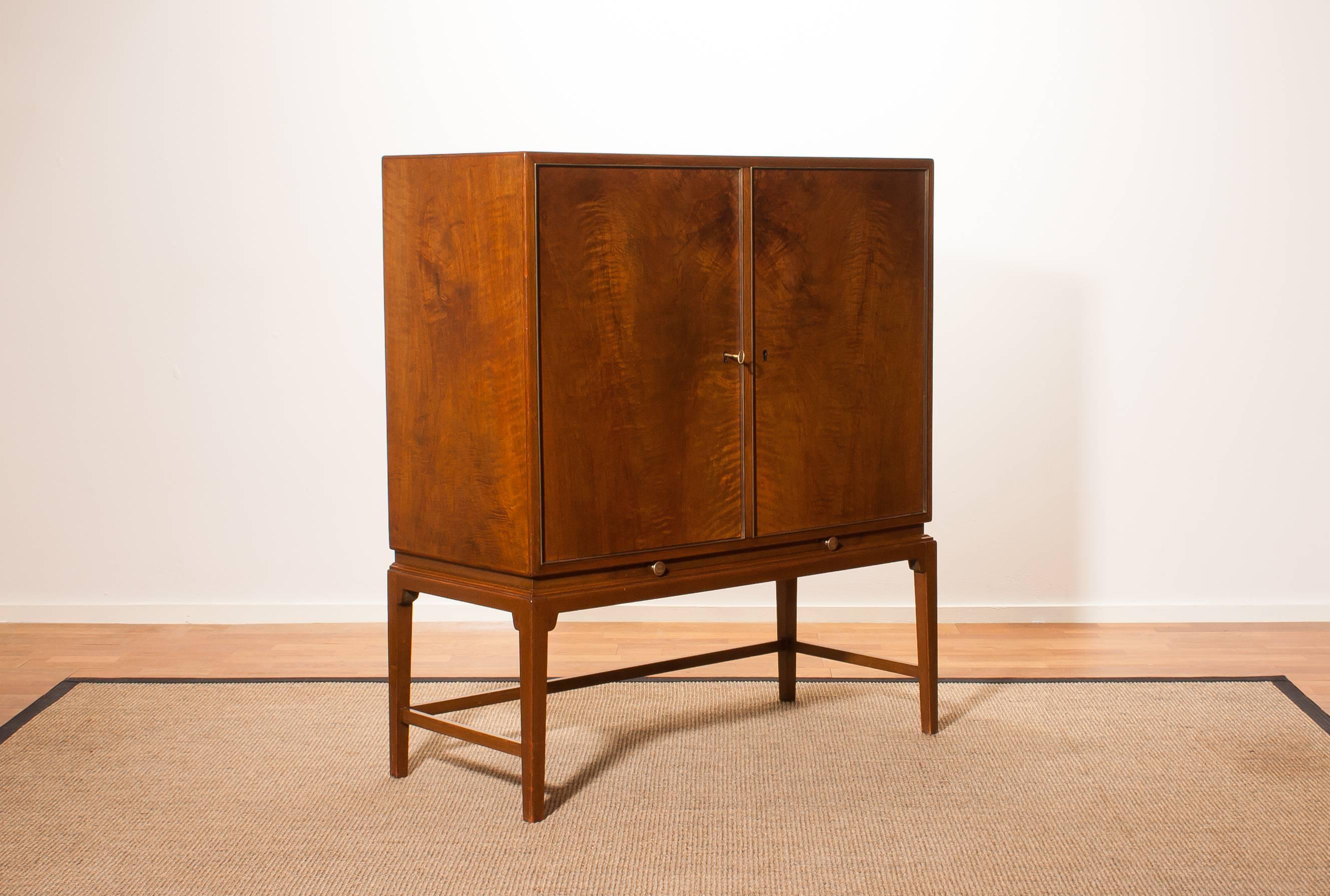 Beautiful burl wood cabinet by Boet Sweden .
This cabinet has five drawers inside and a extendable cocktail leaf made of glass.
The doors are brass framed.
It is in a very nice condition.
Period 1950s
Dimensions : H.116 cm , W.100 cm , D.44 cm