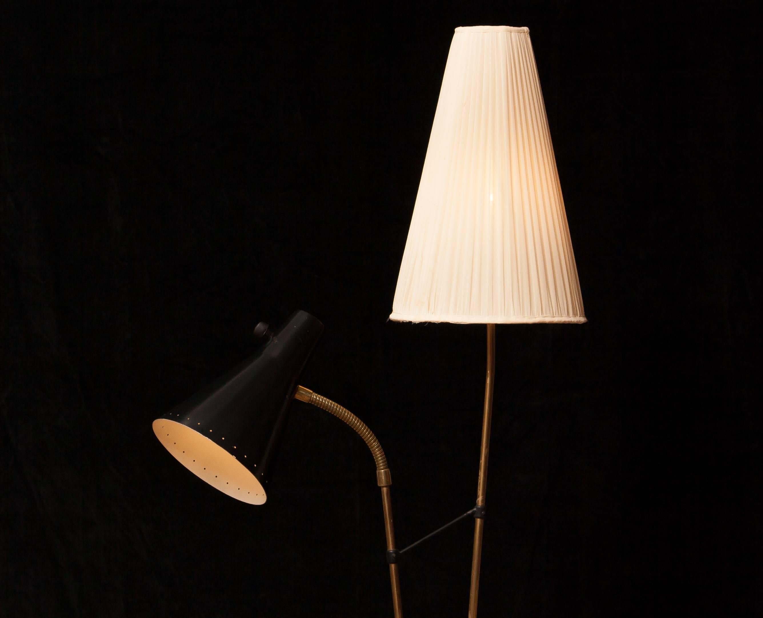 Beautiful floor lamp designed by Hans Bergström for Ateljé Lyktan, Sweden.
This lamp consist of two different shades; one black lacquered metal and one off-white fabric .
The stand is made of brass with a beautiful rare feet.
It is in a very nice
