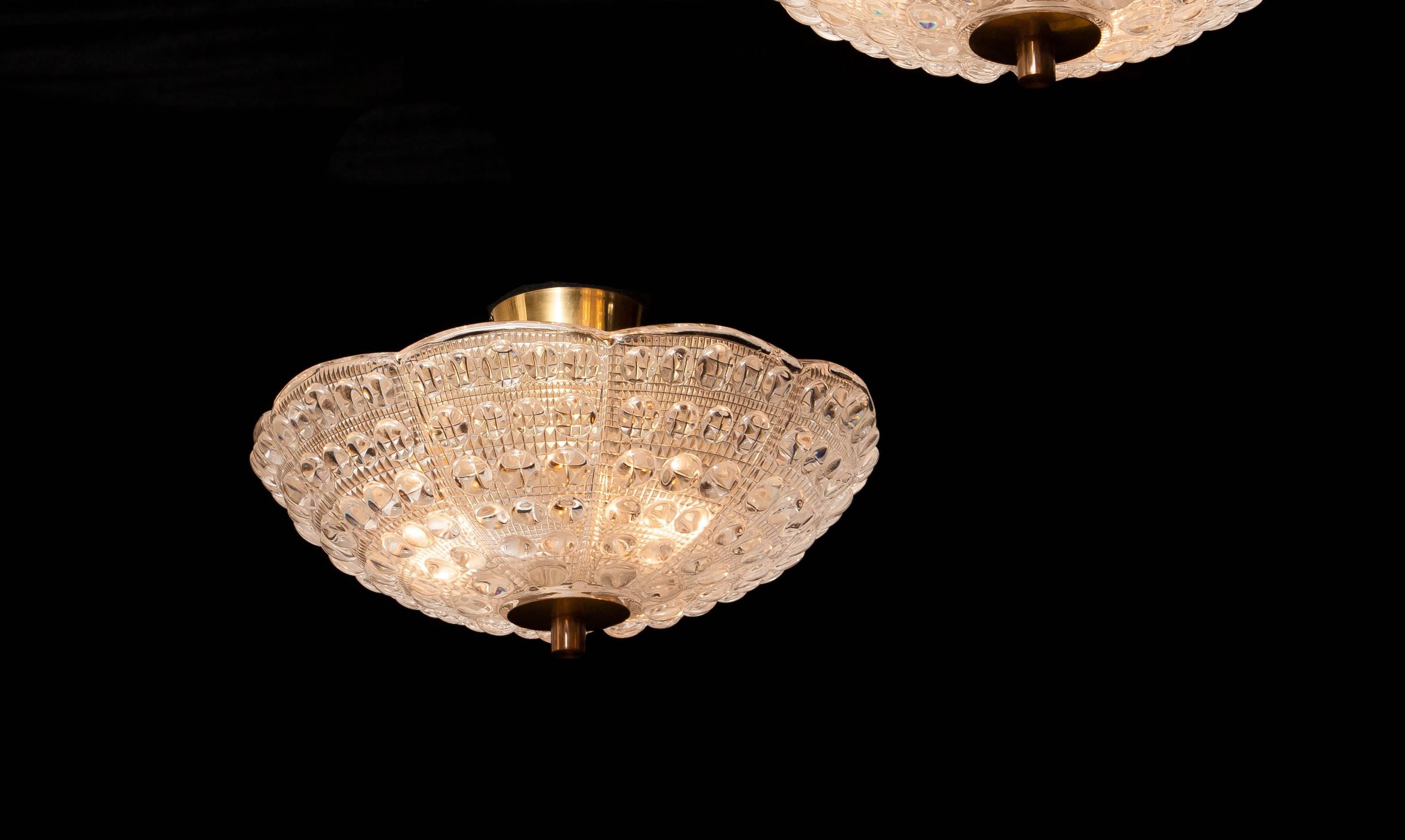 Beautiful pair of ceiling lights designed by Carl Fagerlund for Orrefors, Sweden.
These pendants are made of crystal glass and brass.
They are in a wonderful working condition.
Period 1960s.
Dimensions: H 20 cm , ø 36 cm.