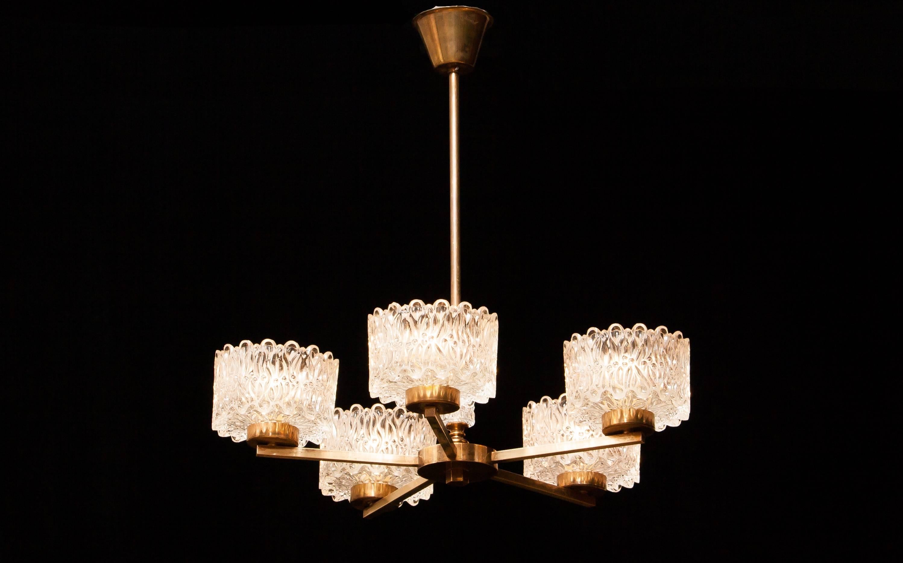 Beautiful chandelier designed by Carl Fagerlund for Orrefors Sweden.
This lamp consist of five crystal glass shades on brass arms.
The chandelier is i a very nice working condition.
Period 1960s
Dimensions: Shade H.9 cm , ø.15 cm
 Total H.60 cm