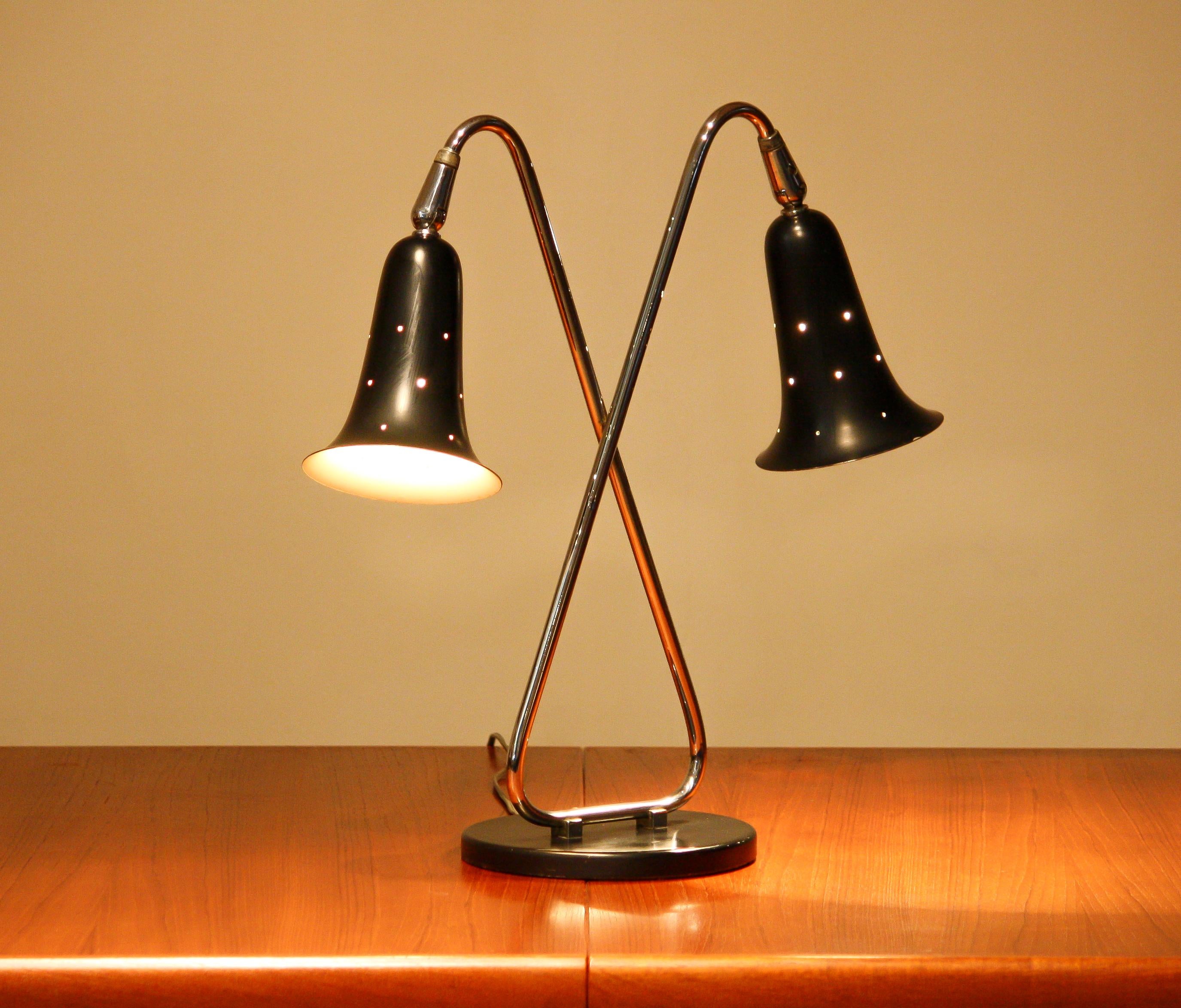 Extremely beautiful black lacquered and chromed metal desk / table lamp, made in the USA, 1950s.
Technically 100% and in good and original condition. Two bulbs E26 / E27 size.

Period 1950s
The dimensions for the shades are: ø14 cm / 5.5 inch -