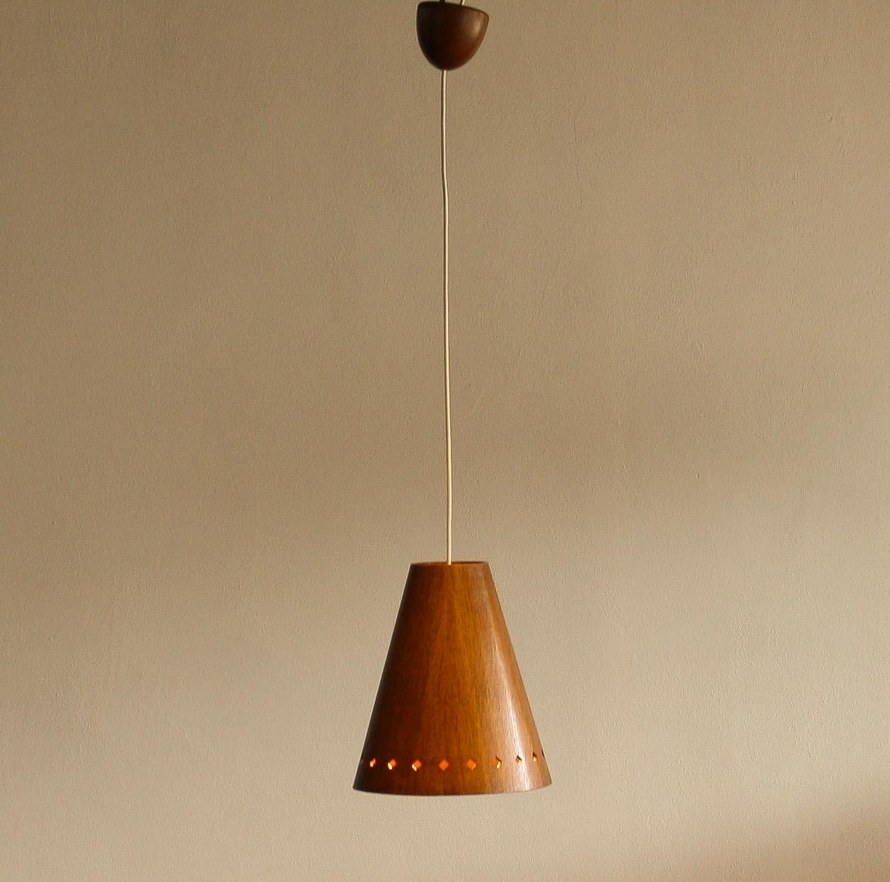 Very nice hanging lamp, model 565, made of wood designed by Uno & Östen Kristiansson for Luxus Vittsjö, Sweden.
The perforation on the shade gives it a beautiful shining.
The lamp is in very good condition.
Period 1950.
Dimension: H 30 cm, Ø 25