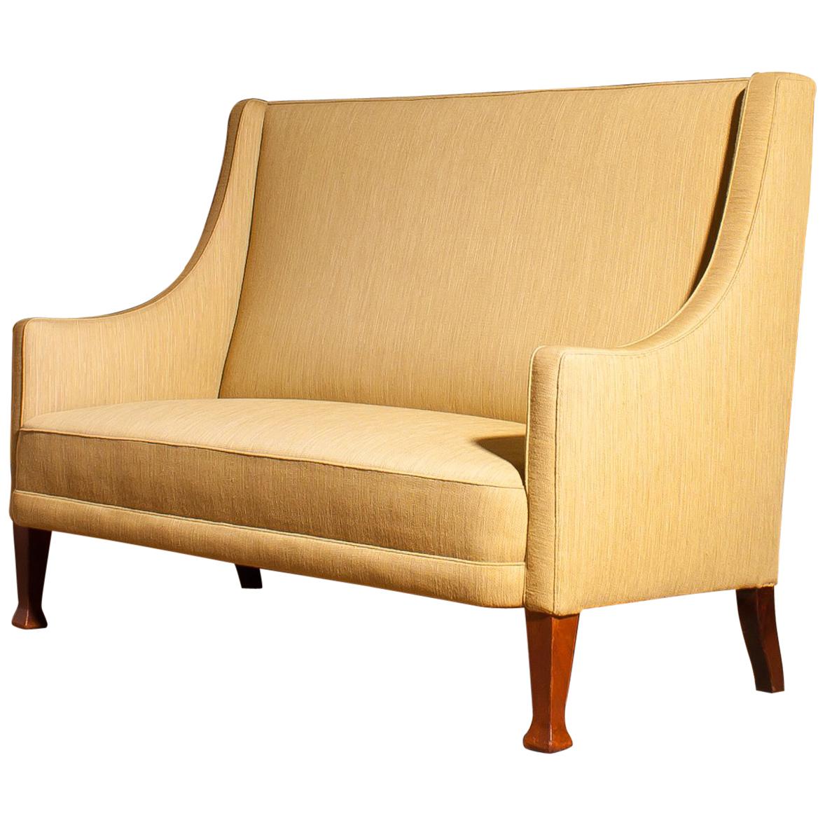 Beautiful high back sofa couch made in Denmark.
The sofa is made of a light yellow fabric on a wooden frame.
It is in a wonderful original condition,
period 1950s.
Dimensions: H 108 cm, W 148 cm, D 75 cm, SH 46 cm.