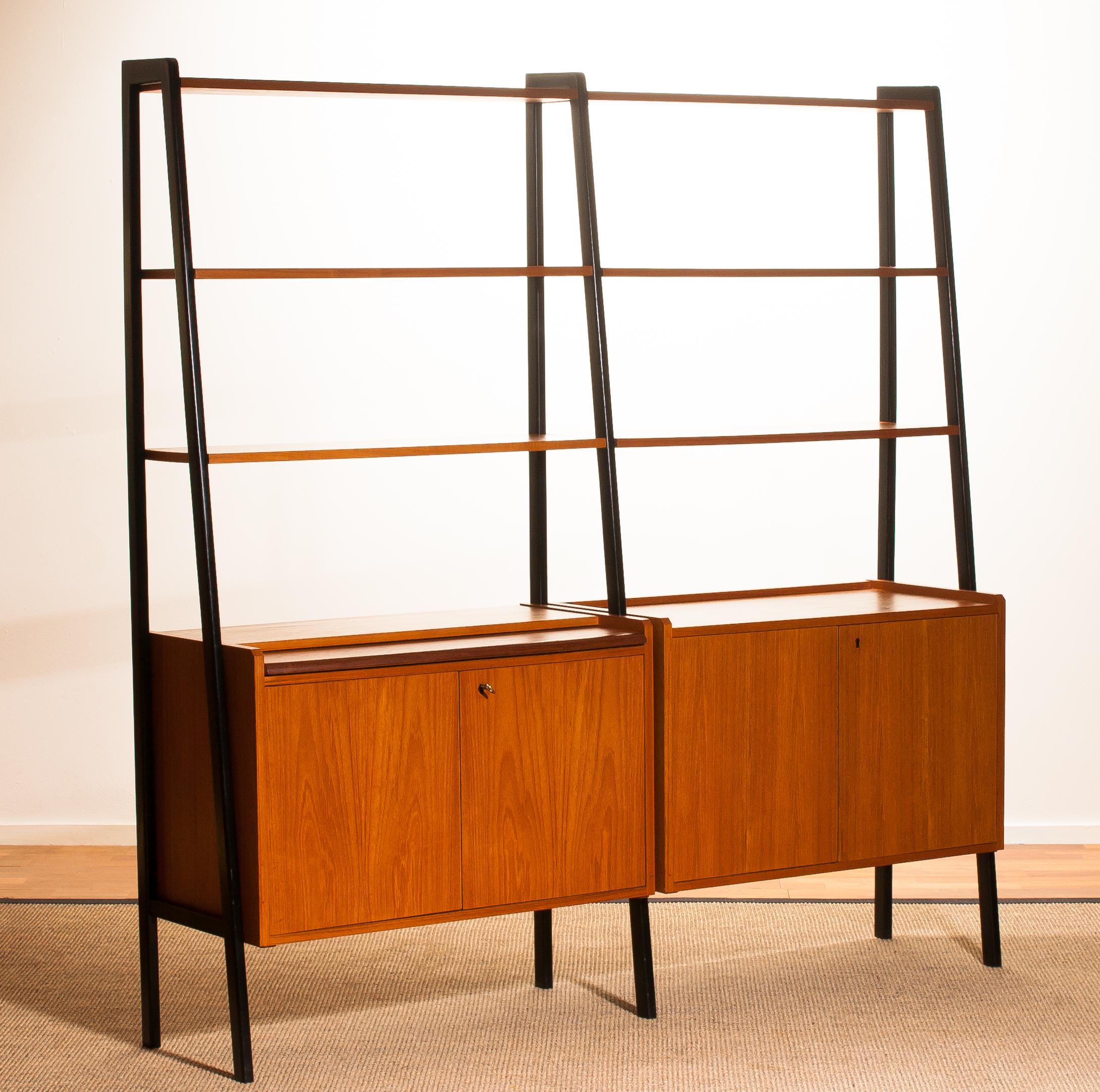 Beautiful double cabinet made of teak with black stands and made in Sweden.
The cabinet contains six shelves and two cabinets with four doors (with original key).
One of the cabinets also has a writing/working desk.
The cupboard is in excellent