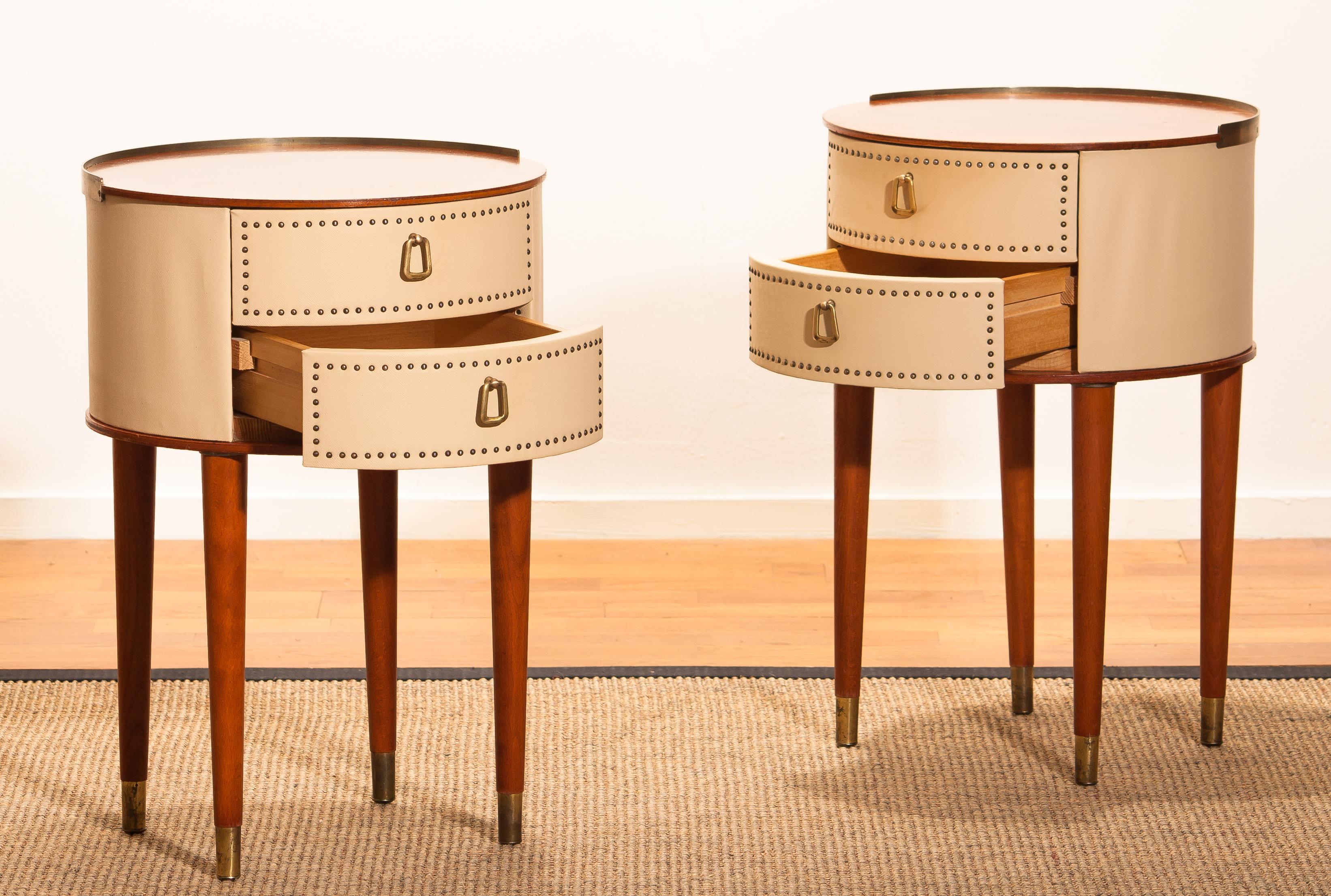 1950s. Mahogany / brass and vinyl, bedside tables or nightstands, on high legs designed by Halvdan Pettersson in the 1950s for Tibro Möbelfabrik Sweden. This set nightstands is in good condition.

Period: 1950s
The bedside tables are: ø 37cm –