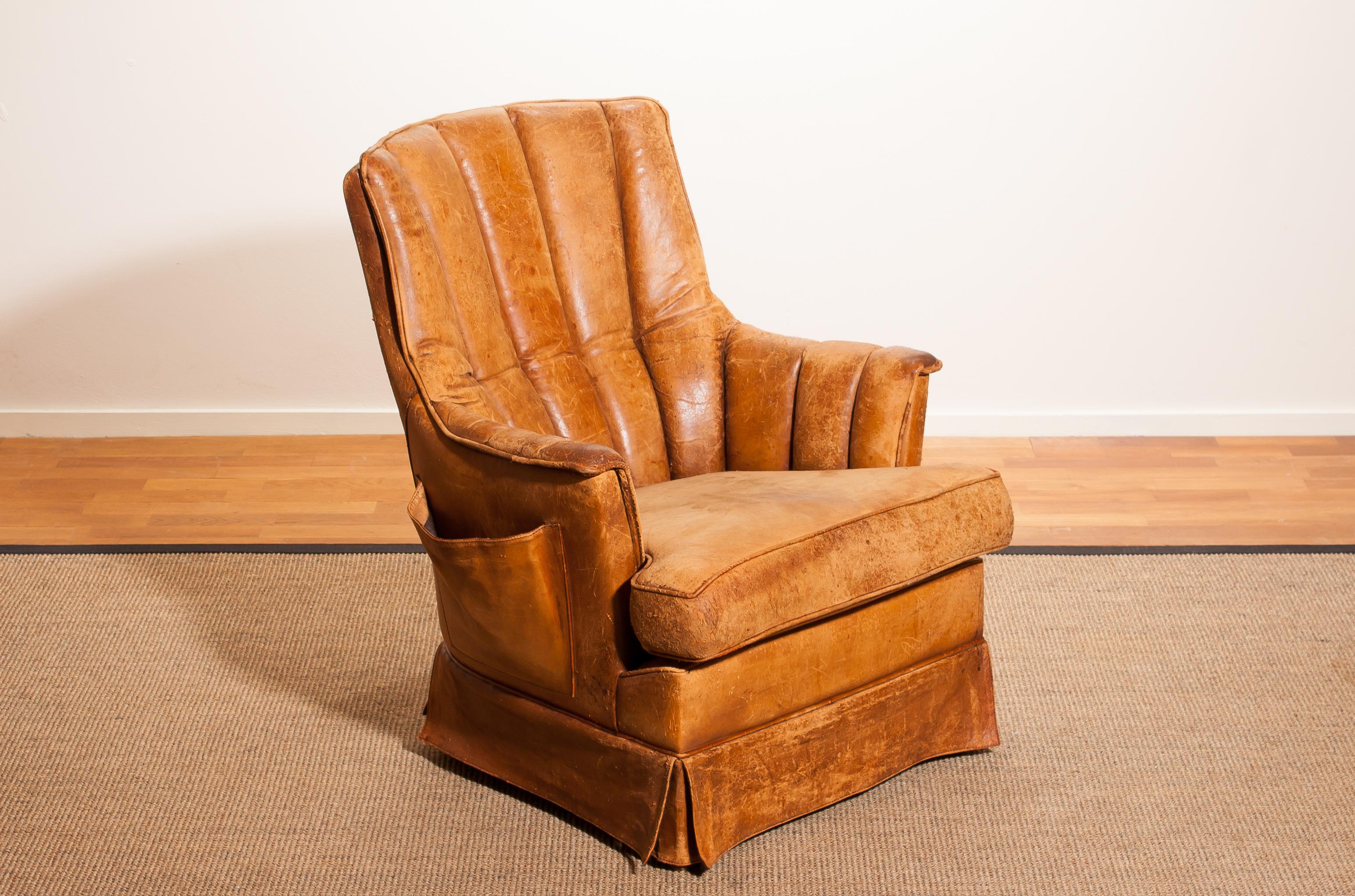 Fantastic club armchair from France.
This chair is made of leather with a skirt and a magazine bag on its side.
It has a greatly used patina.
Period 1940s.
Dimensions: H 85 cm, W 75 cm, D 68 cm, SH 46 cm.