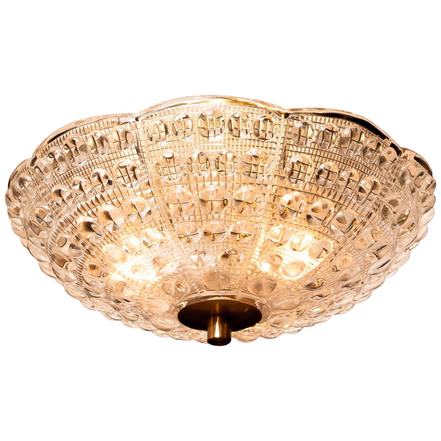 Beautiful ceiling light designed by Carl Fagerlund for Orrefors, Sweden.
This pendant is made of crystal glass and brass.
It is in a wonderful working condition.
Period 1960s.
Dimensions: H 20 cm, ø 36 cm.