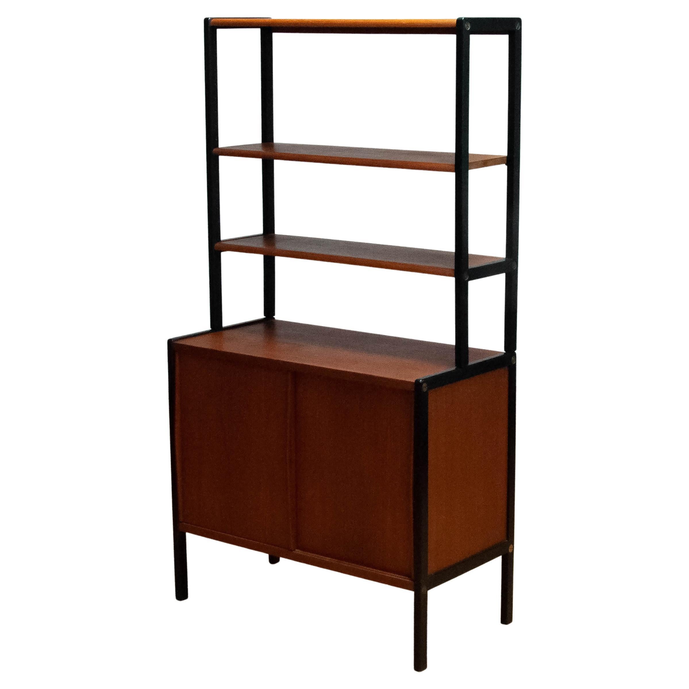 Beautiful Scandinavian Moderen bookcase designed by Bertil Fridhagen for Bodafors in Sweden 1960s.
The lower cabinet has two sliding doors and inside a shelf. Fixed positioned.
On top is a rack with three teak shelfs. The shelf in the middle is
