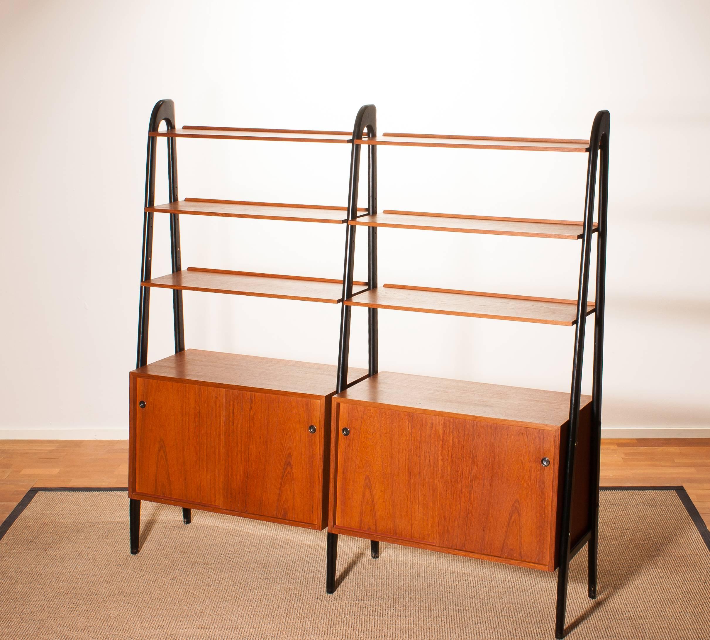 Beautiful double cabinet made of teak with black stands by Bertil Fridhagen, Sweden.
Because the cupboard is pretty slim and open of form I it is also very suitable to use it as a room divider.
The cabinet contains six shelves and two cabinets