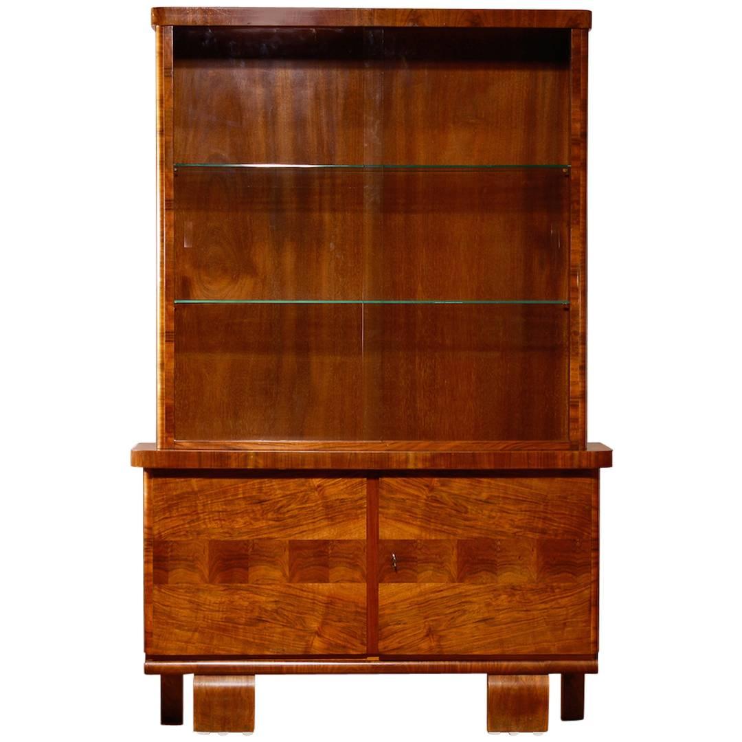 Beautiful Art Deco display cabinet.
The cabinet is made of beautiful walnut veneer and is in a perfect condition.
The original sliding glass doors are still entirely intact. (Just one little invisible chip on the inside of the glass door).
Period