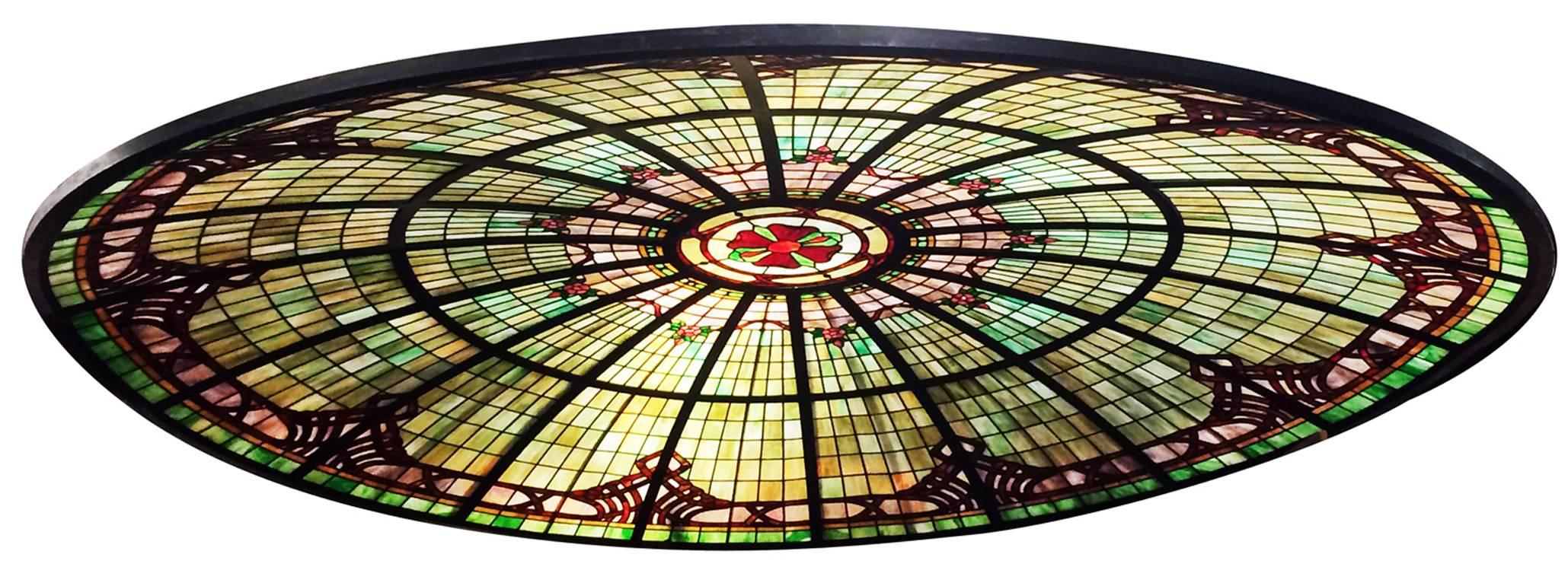 This vivid stained and jeweled glass ceiling dome depicts a wild rose theme from the center outward. Solid steel frame holds the sections of glass panel and comes apart easily for shipping and installation. Not suitable for outdoor application, but