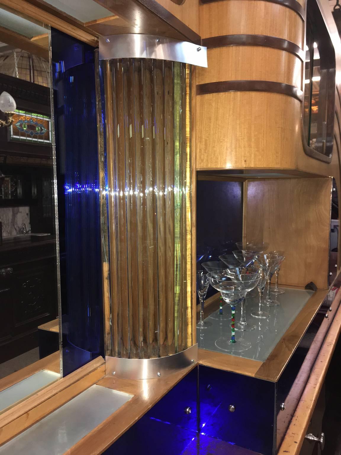 Two-toned walnut, mahogany and birch deco bar with original blue and regular glass mirrors, cabinets, shelving, showcases and glass rods. Fantastic period look and ready to go!