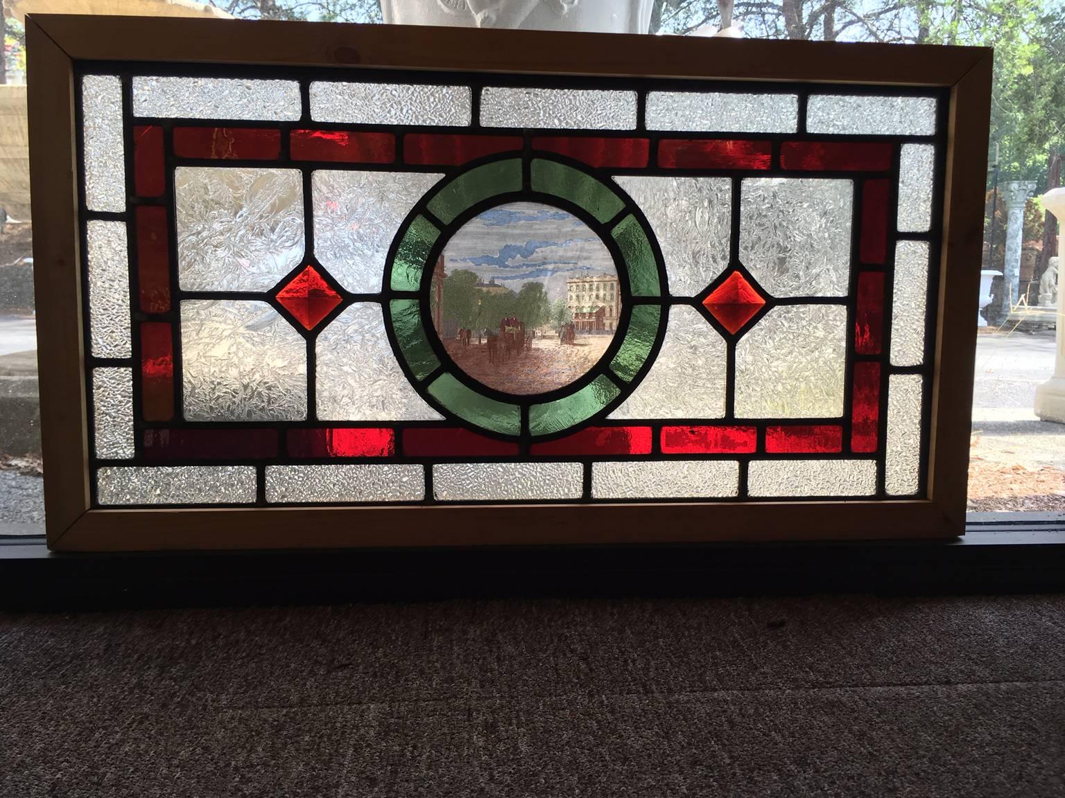 This great little English stained, leaded, painted and jeweled cottage window has a small painted scene depicting a Victorian London street flanked by bright red window jewels and set in a new frame for stability.