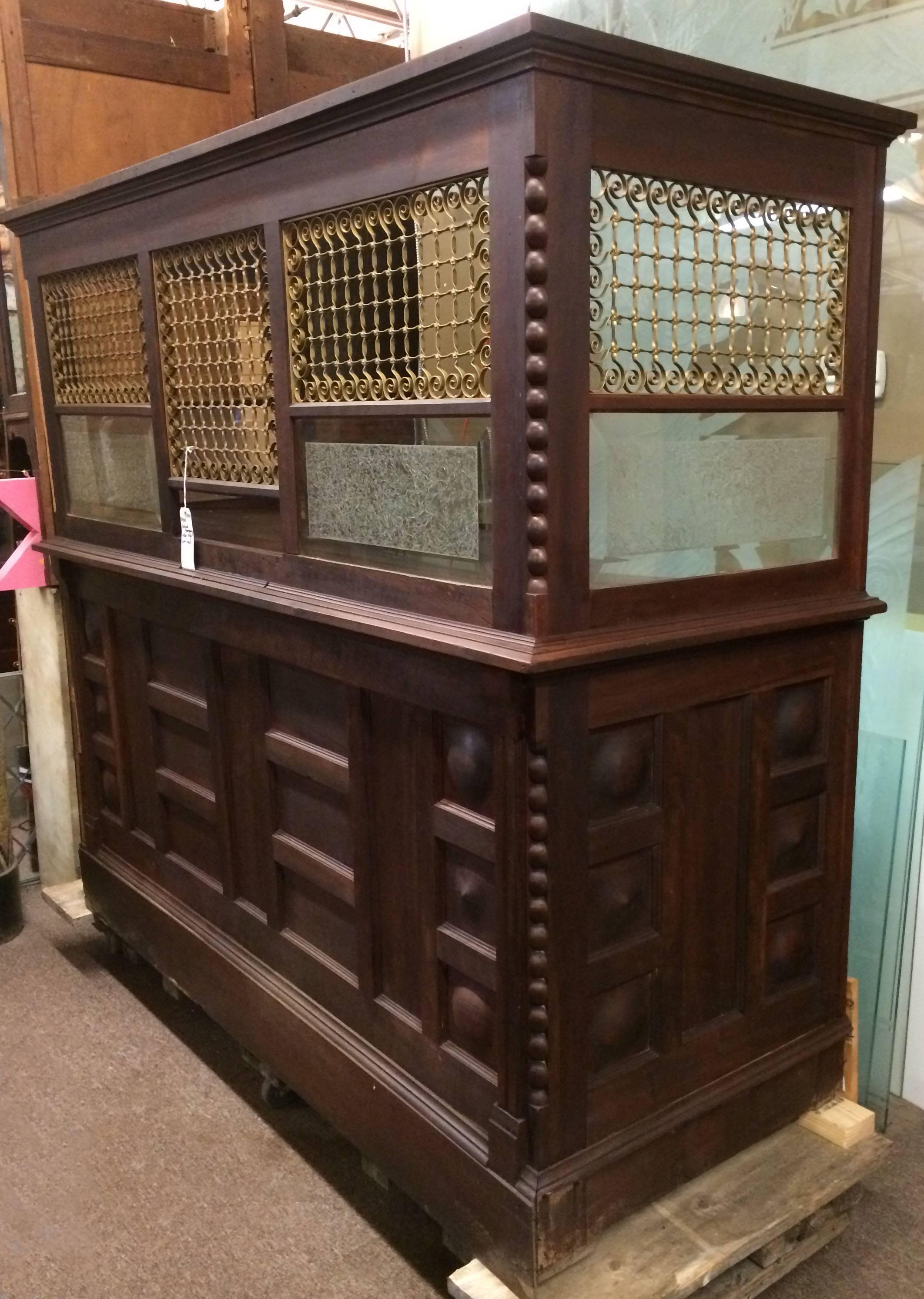 This antiques teller cage may have been from a bank or anywhere money was exchanged. Piece of the original labels with wiring info are still attached on the top inside of the cage. Made from raised paneled mahogany, bronze grates and frosted glass,
