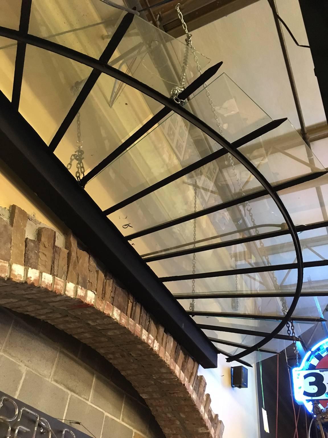 This half round wrought iron canopy is from Paris, circa 1910s. Glass has been replaced with tempered safety glass, but the iron is original.