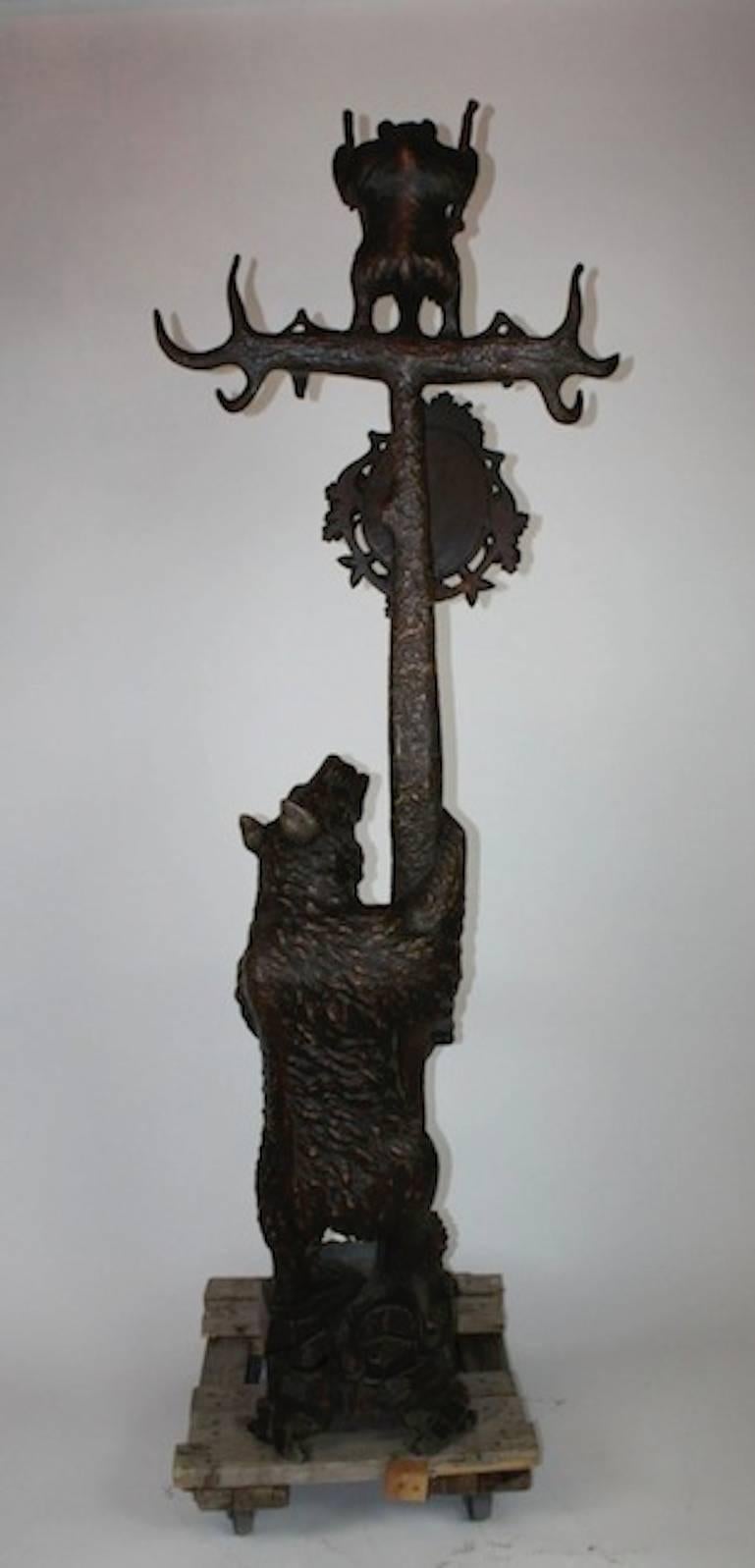 Exceptional 19th century carved black forest beat hall tree with umbrella stand and mirror. The lower bear looking upward into the 