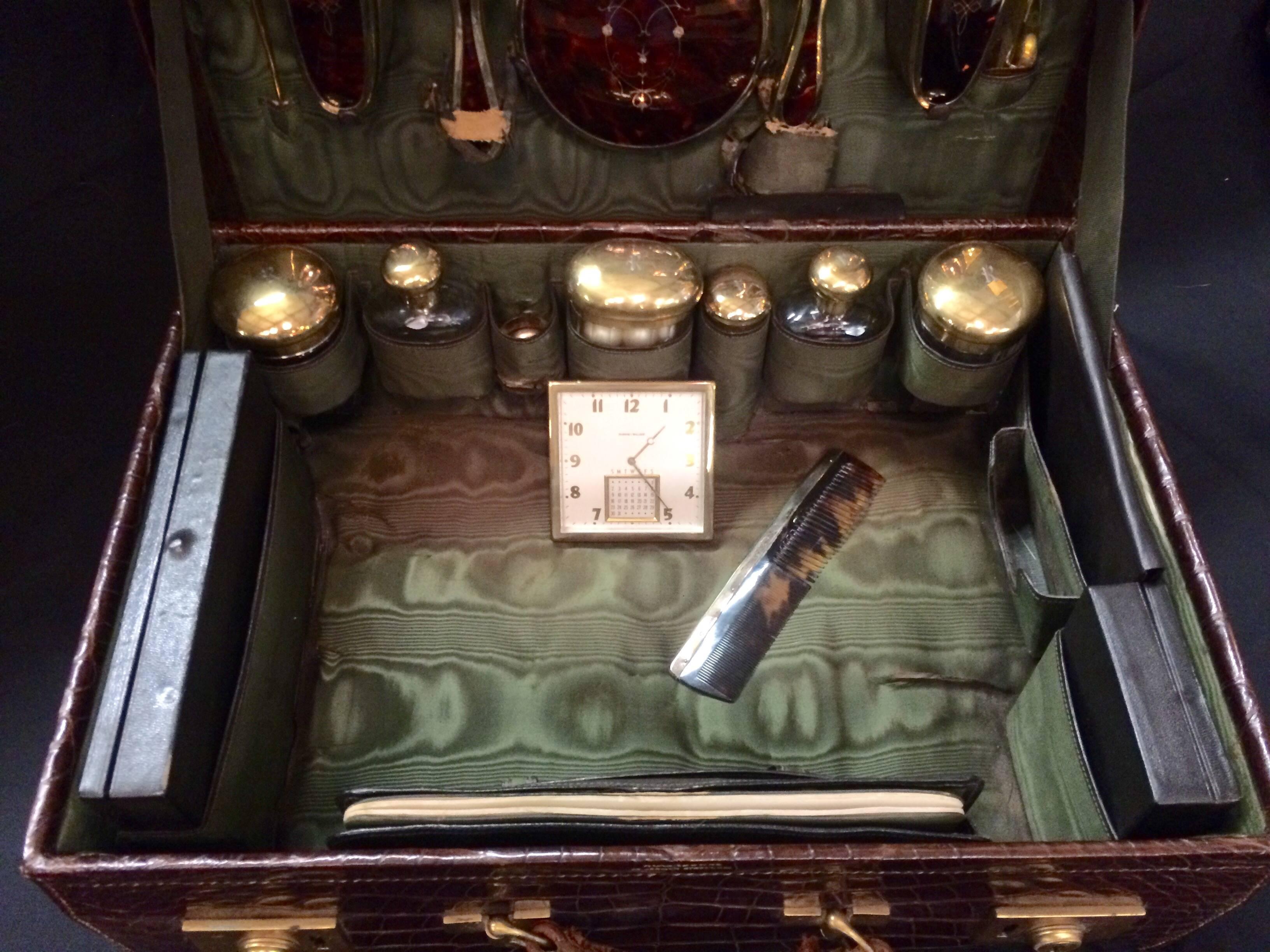 Late 19th century Art Deco men’s traveling grooming case with accessories including handblown and beveled glass bottles with gold lids engraved with initial "R. Set includes three gold inlaid brushes, one mirror, shoe horns, Phinney-Walker