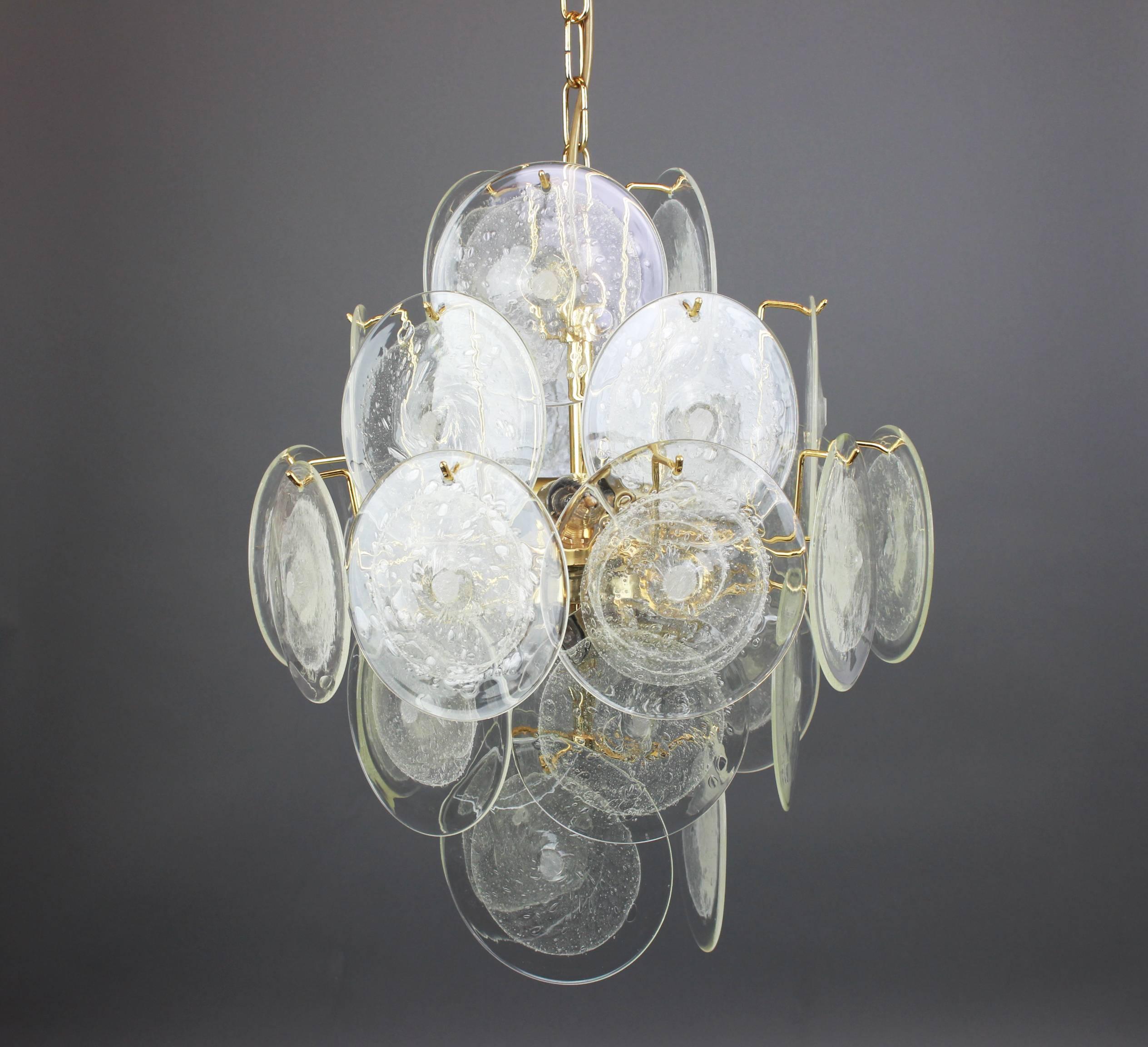 Wonderful ice glass disc chandelier by Vistosi, Italy, 1970s.

This spectacular mouth blown glass disc chandelier is characteristic of the design vocabulary of Gino Vistosi: simple, geometric shapes and monochrome colours executed in the cased glass
