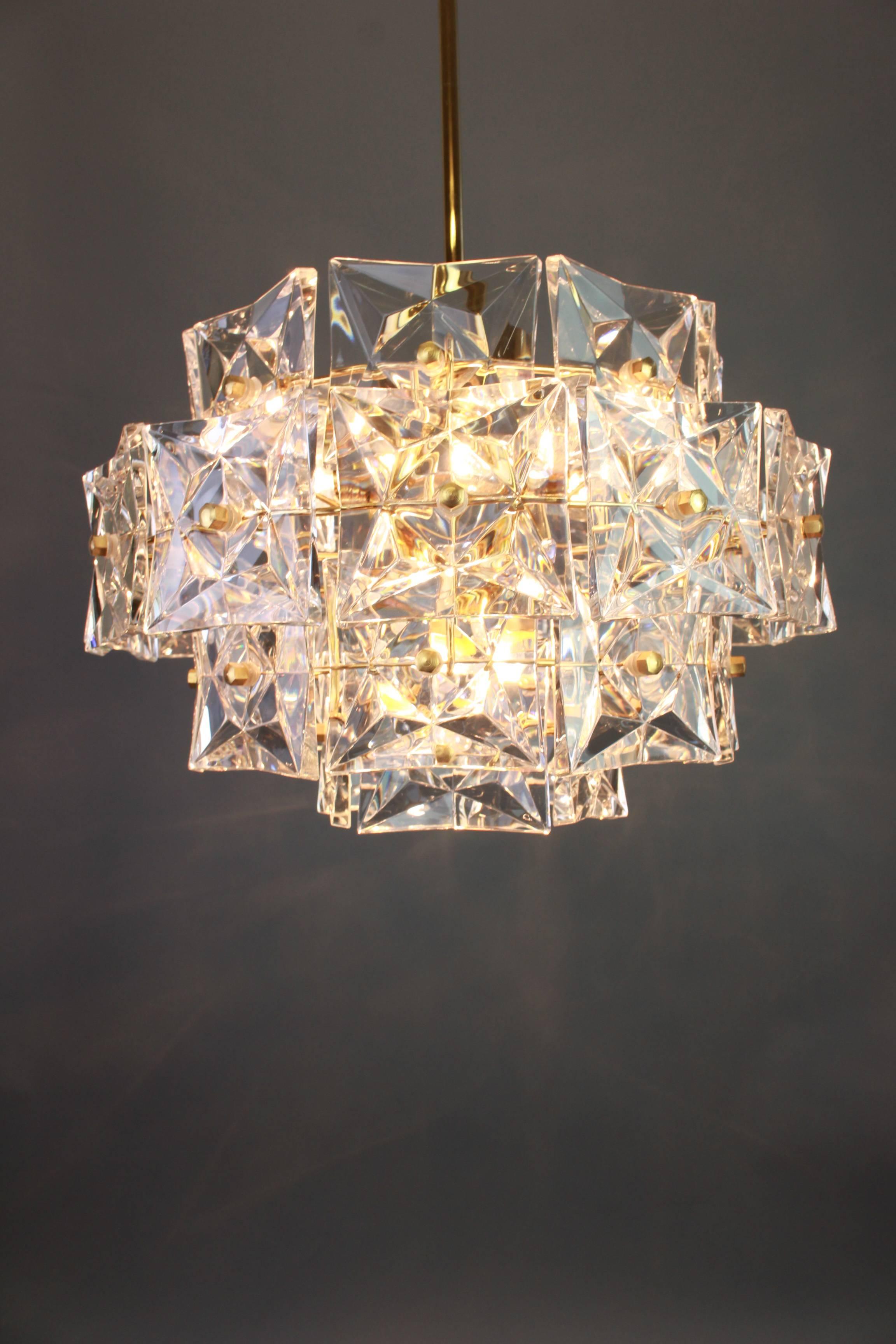 A stunning four-tier chandelier by Kinkeldey, Germany, manufactured in circa 1970-1979. A handmade and high quality piece. The ceiling fixture and the frame are made of brass and has four rings with lots of facetted crystal glass elements.

Sockets: