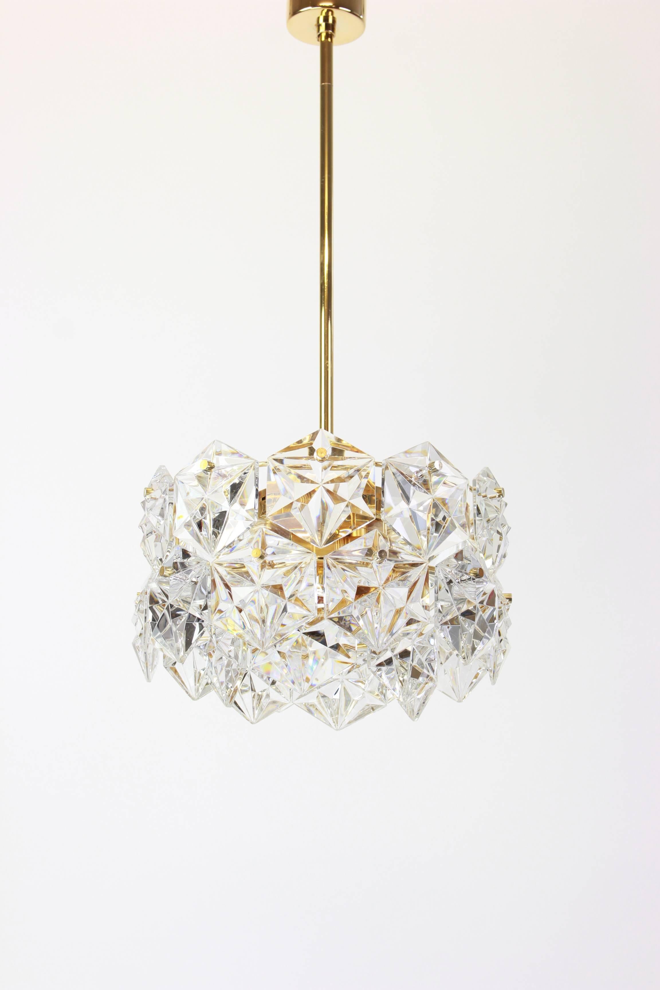 A stunning three-tier chandelier by Kinkeldey, Germany, manufactured in circa 1970-1979. A handmade and high quality piece. The ceiling fixture and the frame are made of brass and has four rings with lots of facetted crystal glass